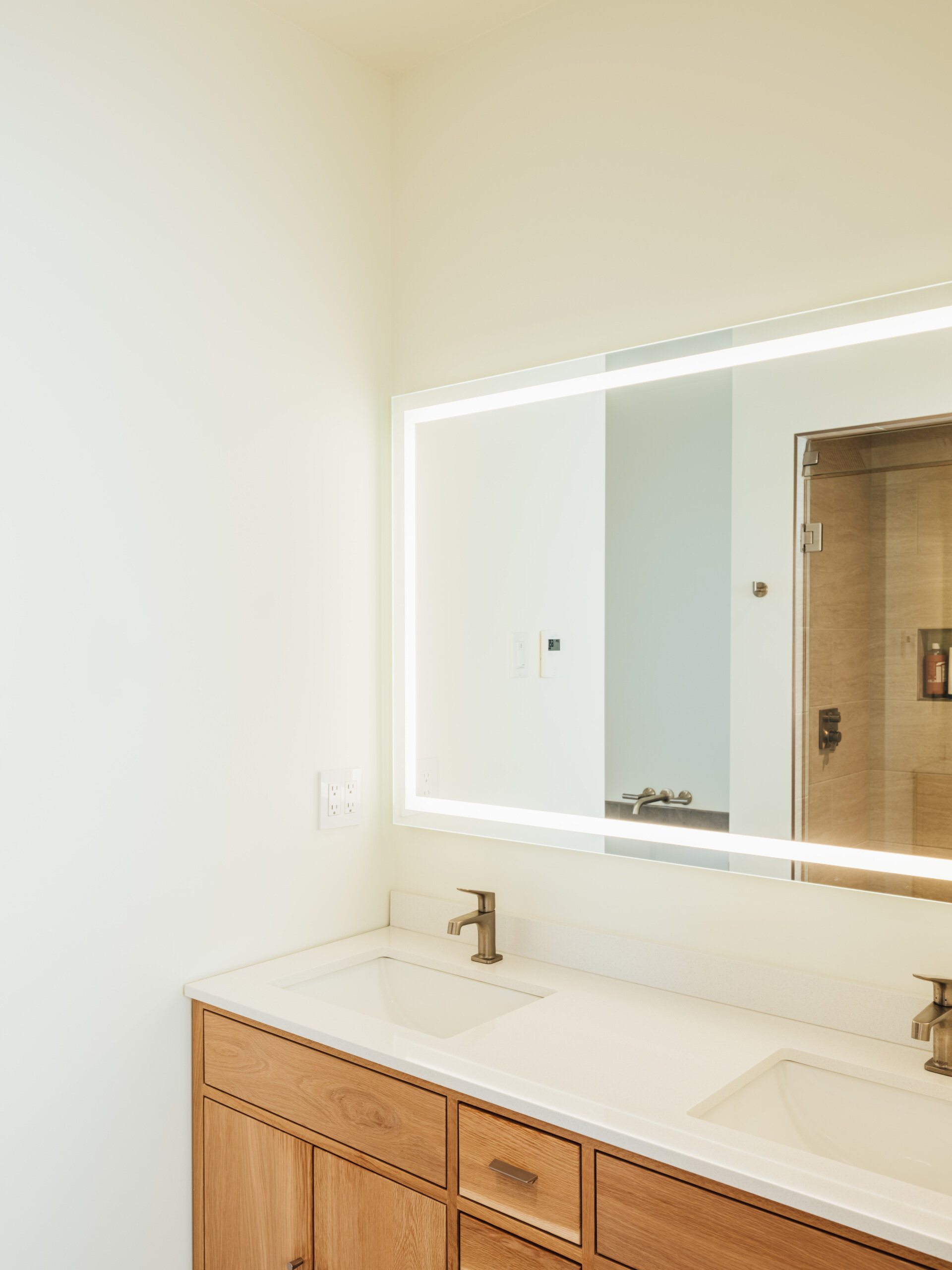 Soft light, calm surfaces, and a curated view create a sense of retreat in the ensuite. Every detail feels intentional, from the quiet materials to the way sunlight drifts through the space.