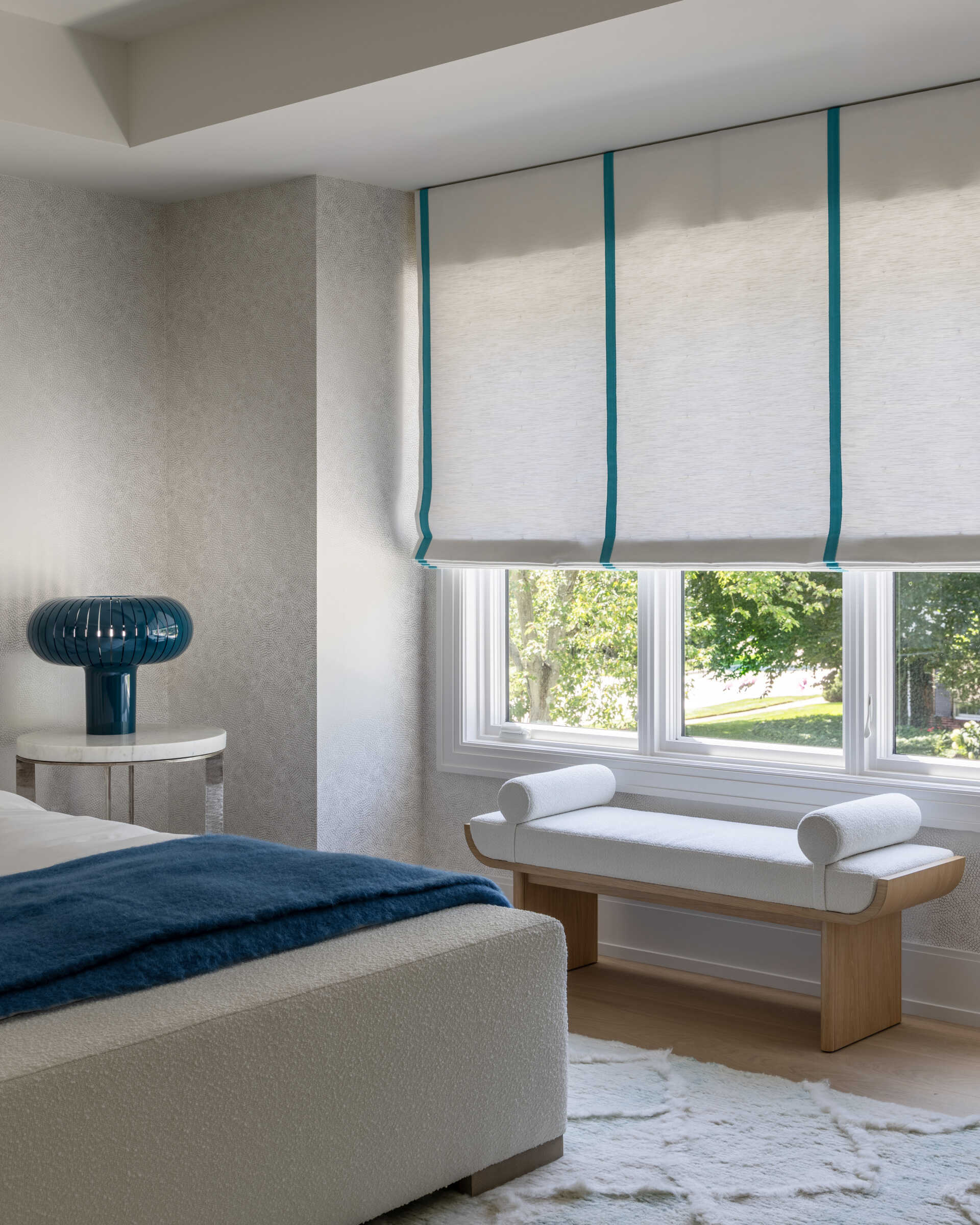 Contemporary bedroom with bench by the window.