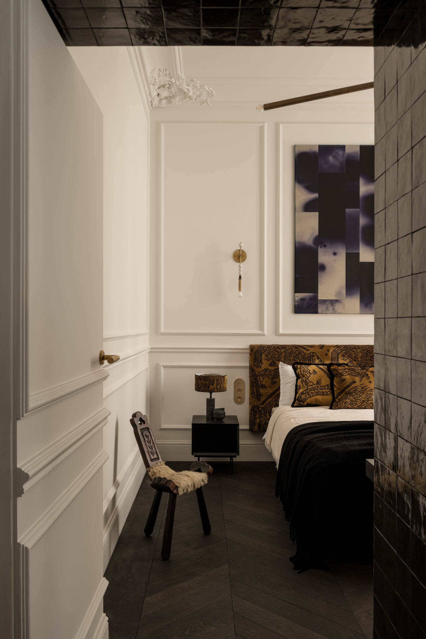 A concealed door melts into the wall mouldings, leading to the bedroom through a tiled threshold that glimmers like a secret passage. It’s a clever, poetic moment that turns a small transition into pure design theatre.