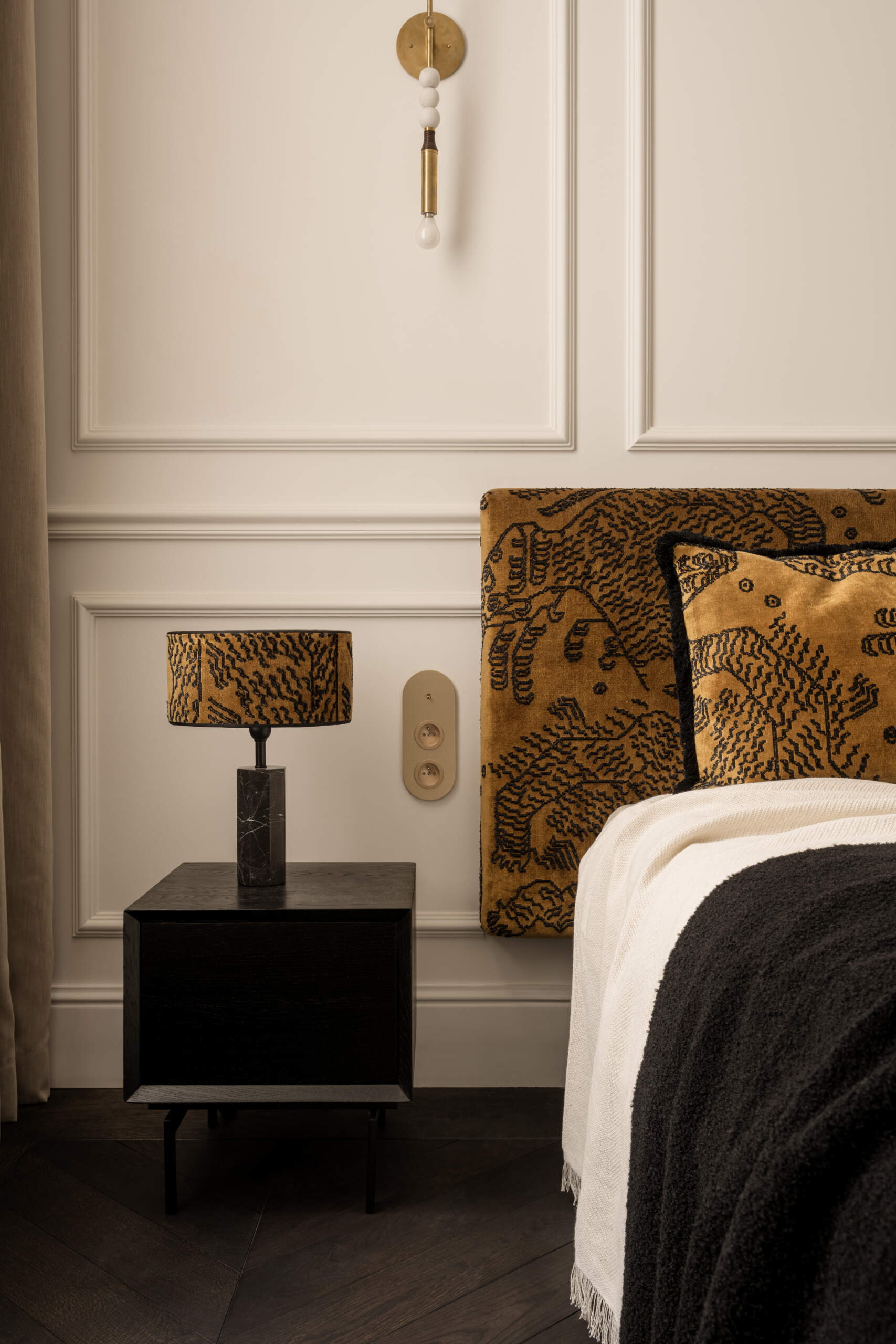 The bed appears to hover, supported by a hidden central leg. Wrapped in Dedar Milano fabric and accented by brass sconces, the bedroom feels serene and weightless. Artworks, sculptures, and handcrafted objects give it soul and quiet personality.