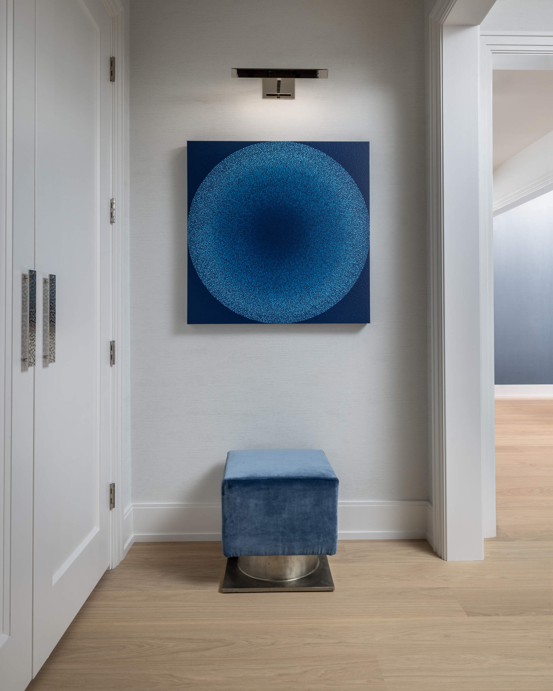 The entryway keeps it simple and serene. Clean-lined storage, a statement mirror, colorful artwork, and warm wood underfoot say you can exhale now. It is softly styled rather than showy, which makes the rest of the tour feel even more considered.