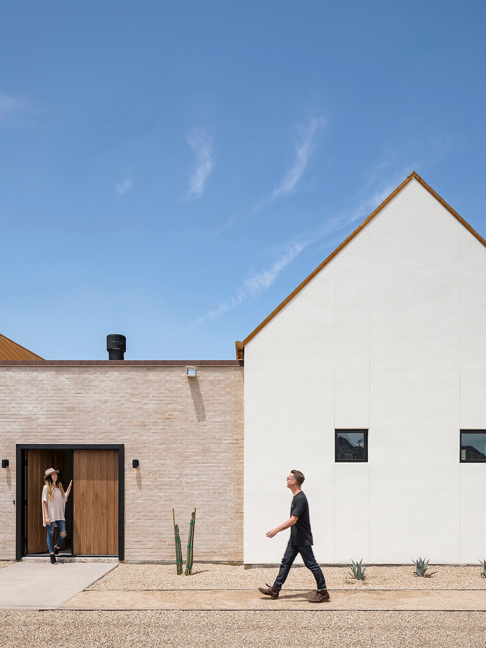 A modern desert home in Phoenix blends mission-inspired forms, white brick walls, and a rusted metal roof to capture Arizona’s light and history.