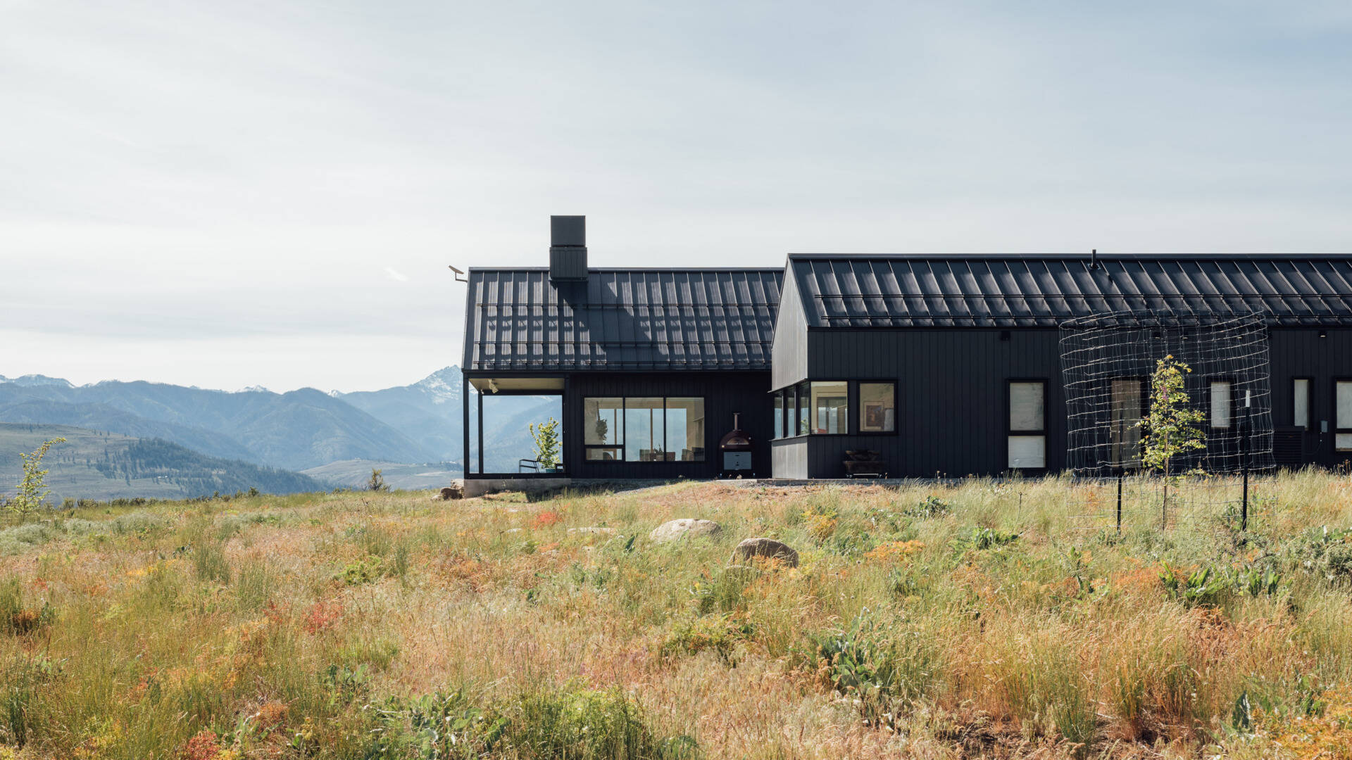 Two matte-black gabled volumes stand quietly against the Methow Valley landscape. The design by Syndicate Smith trades glass walls for carefully framed openings, creating a modern home that feels both grounded and deliberate.