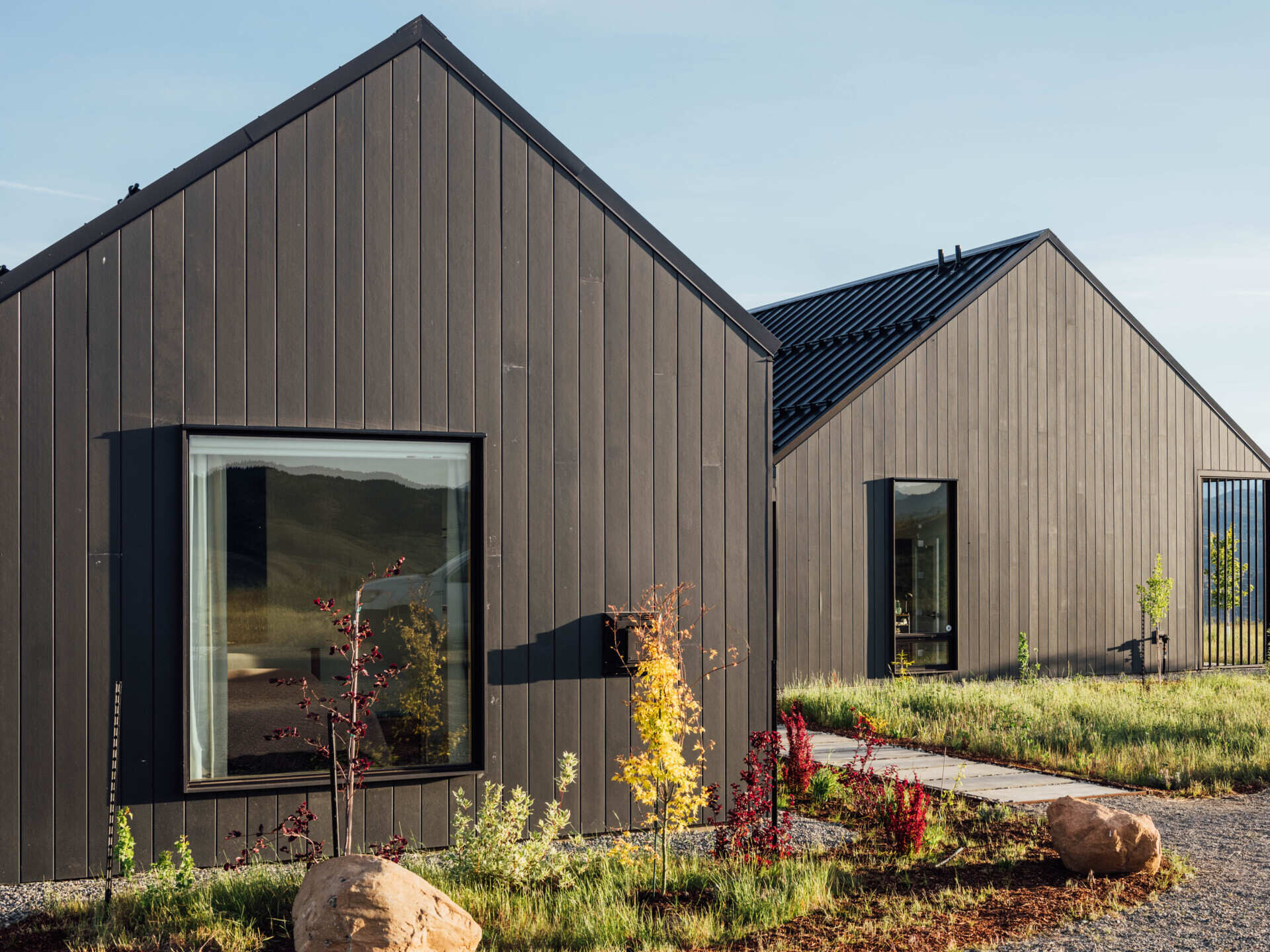 Two matte-black gabled volumes stand quietly against the Methow Valley landscape. The design by Syndicate Smith trades glass walls for carefully framed openings, creating a modern home that feels both grounded and deliberate.