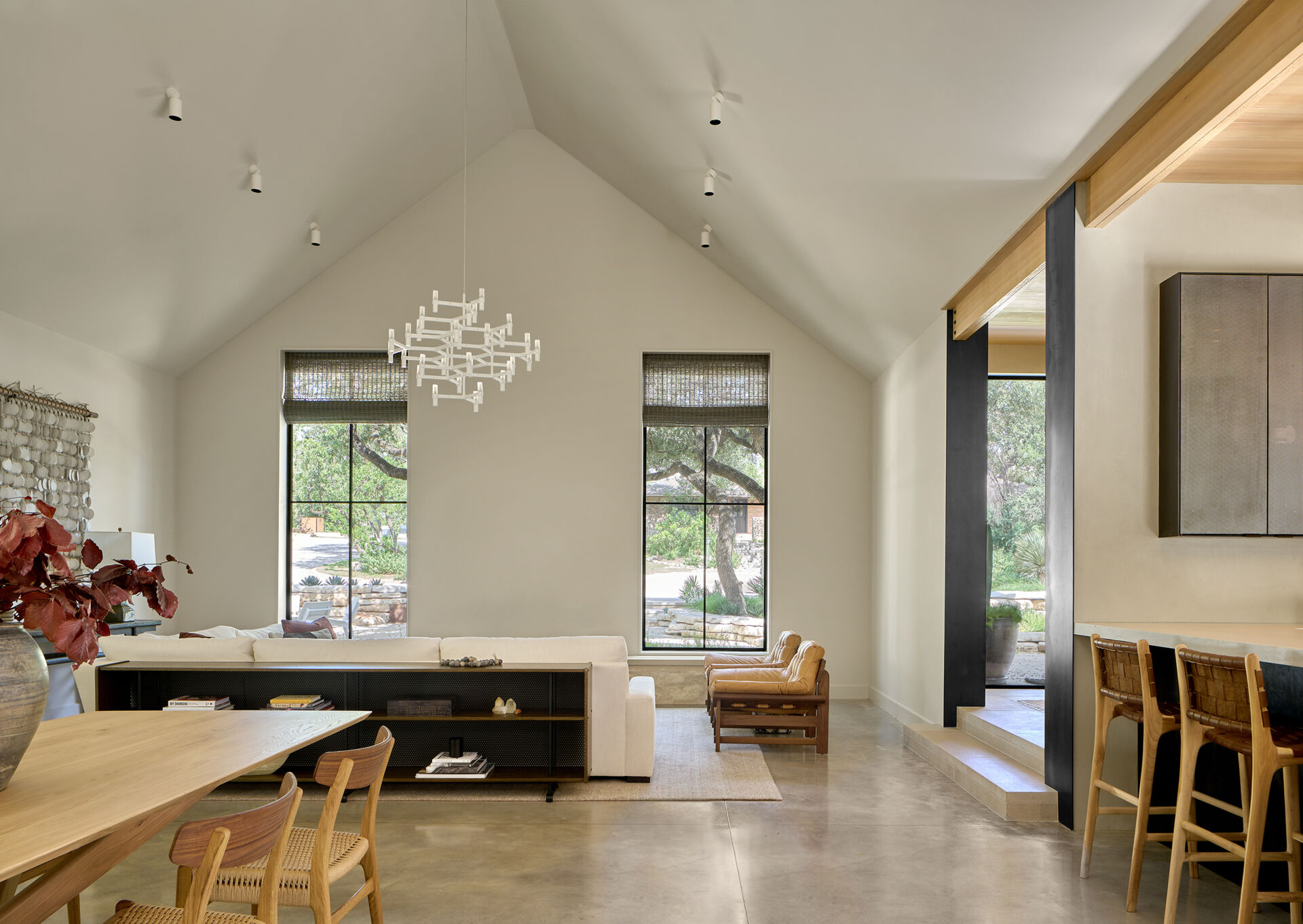 The living room frames the preserved oak tree, a design decision that defines the architecture and interiors.