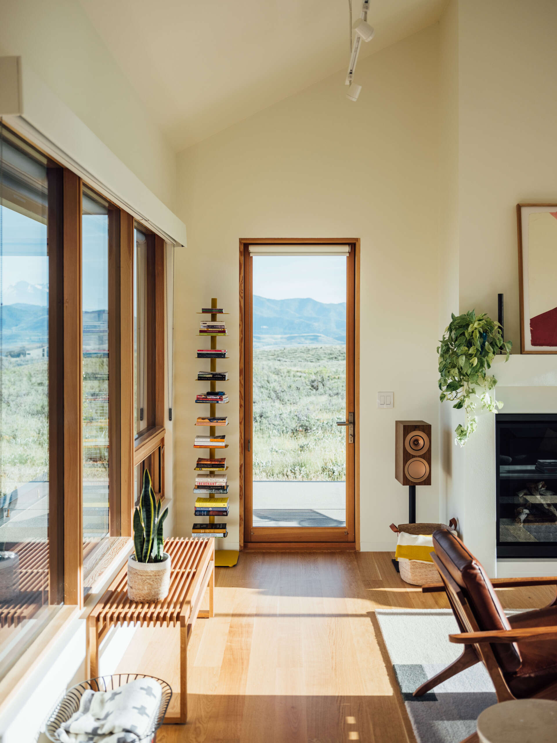 The living room balances warmth and restraint. Gray tones and timber finishes let the landscape take the lead, while the nearby window seat adds a lived-in, human touch to the architecture.