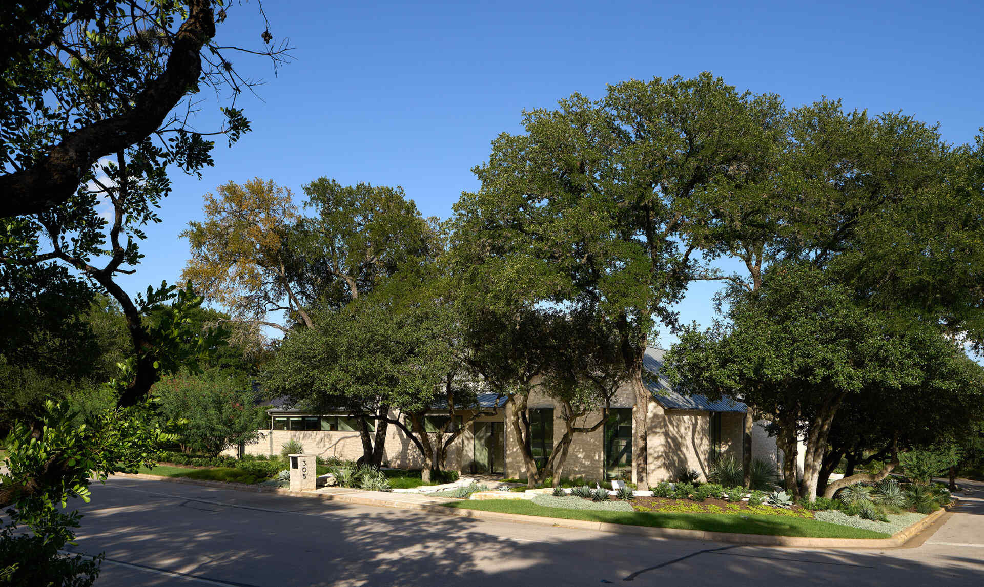A modest street view hides a courtyard home filled with natural light, limestone, and wood by Furman & Keil Architects.