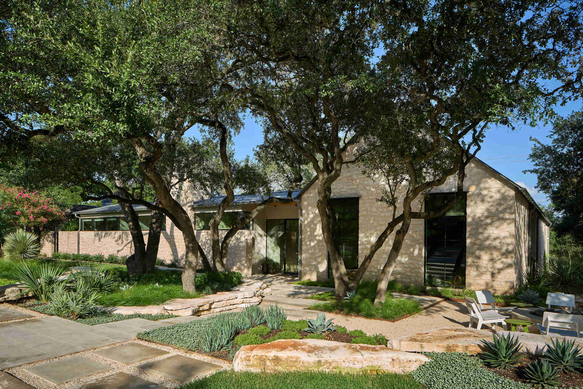 A modest street view hides a courtyard home filled with natural light, limestone, and wood by Furman & Keil Architects.