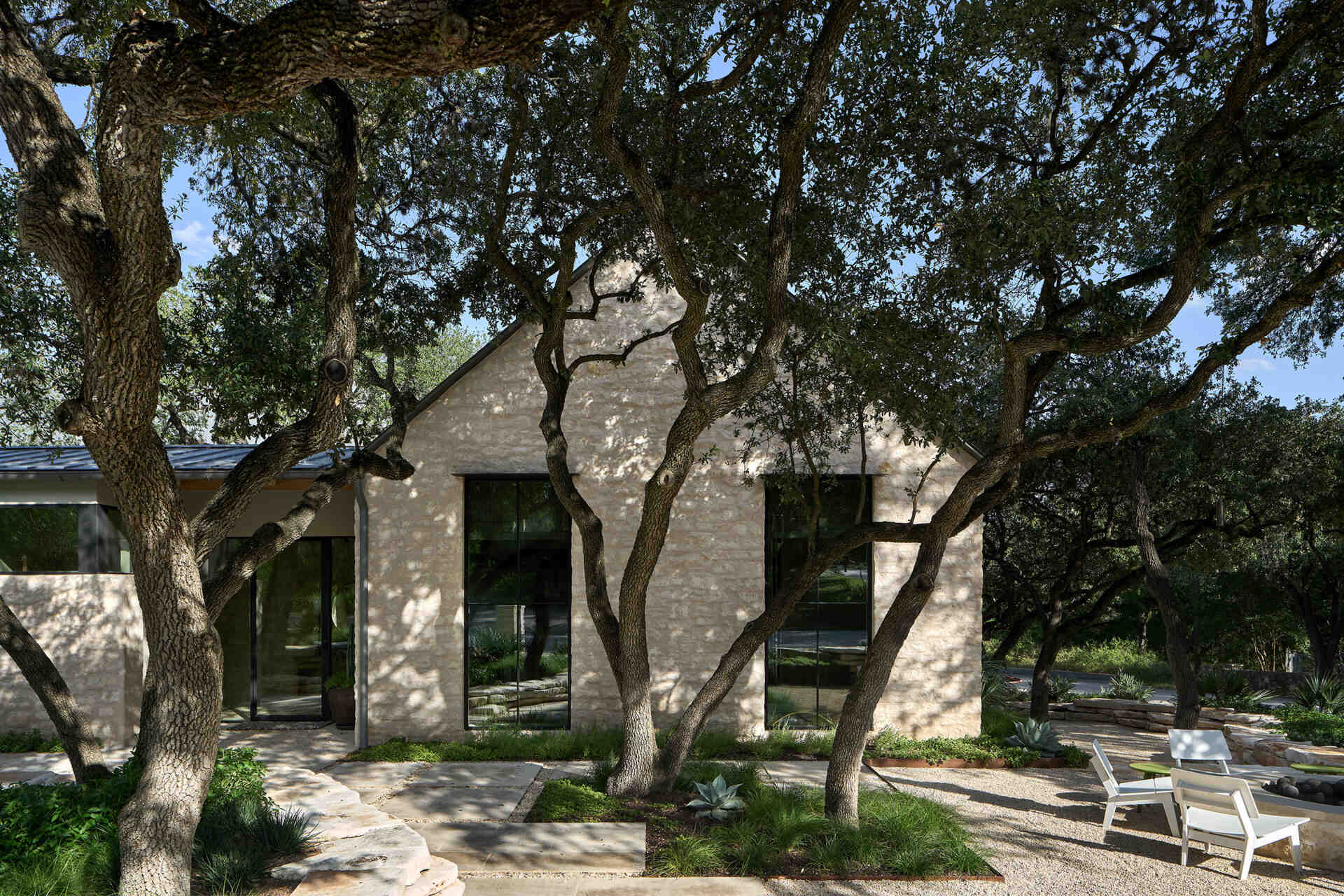 A modest street view hides a courtyard home filled with natural light, limestone, and wood by Furman & Keil Architects.
