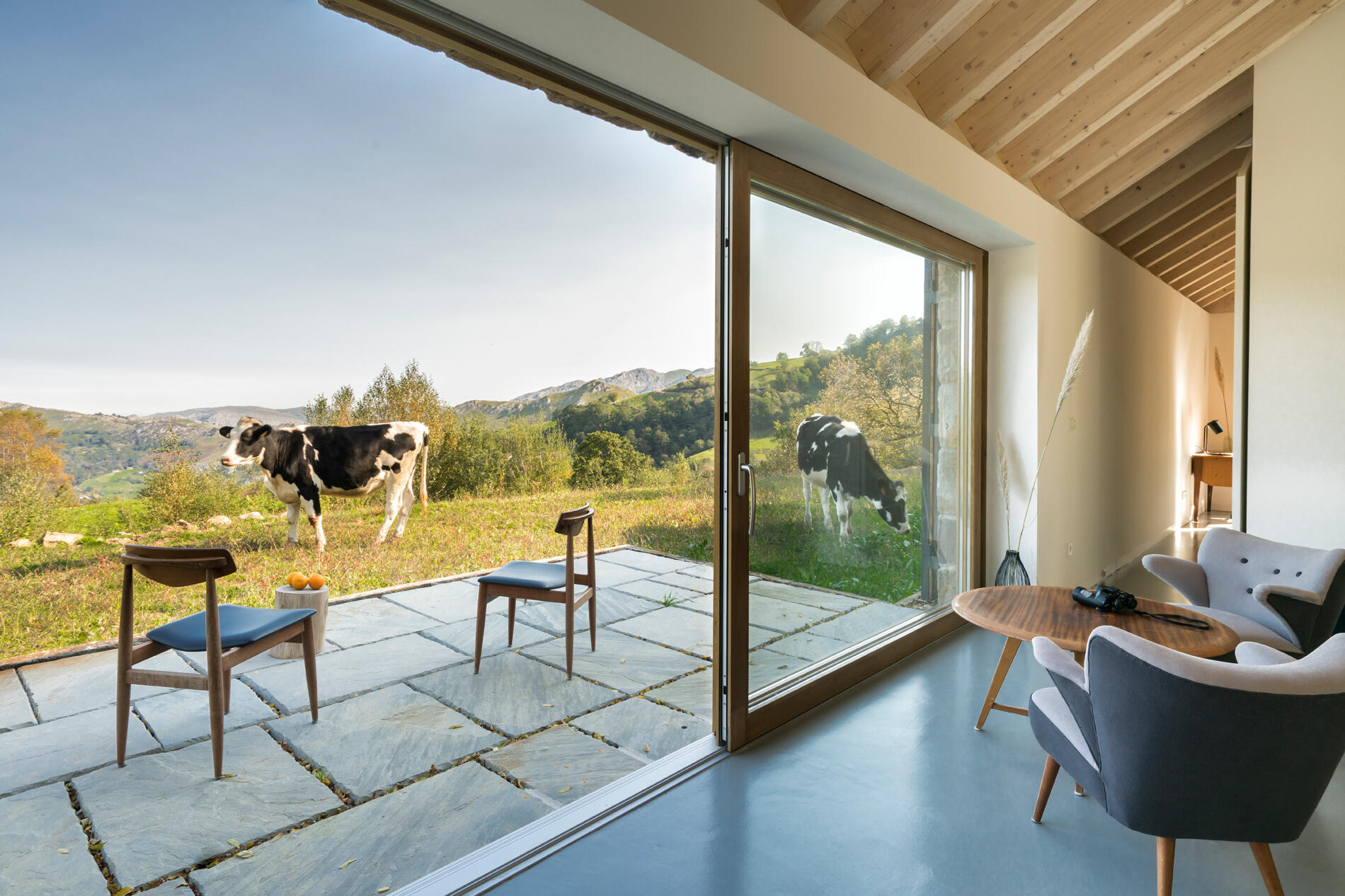 A modern stone cottage that opens to a patio.