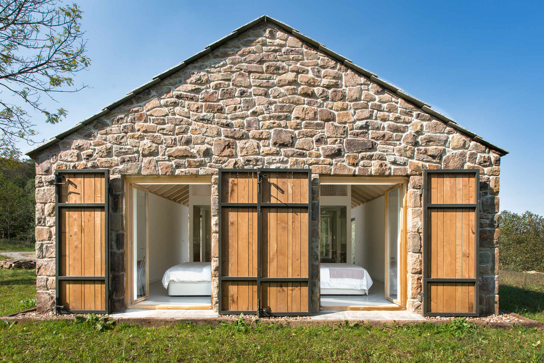 Every bedroom of this stone cottage opens out to the grassy field beyond, catching the soft morning light that pours in from the east.