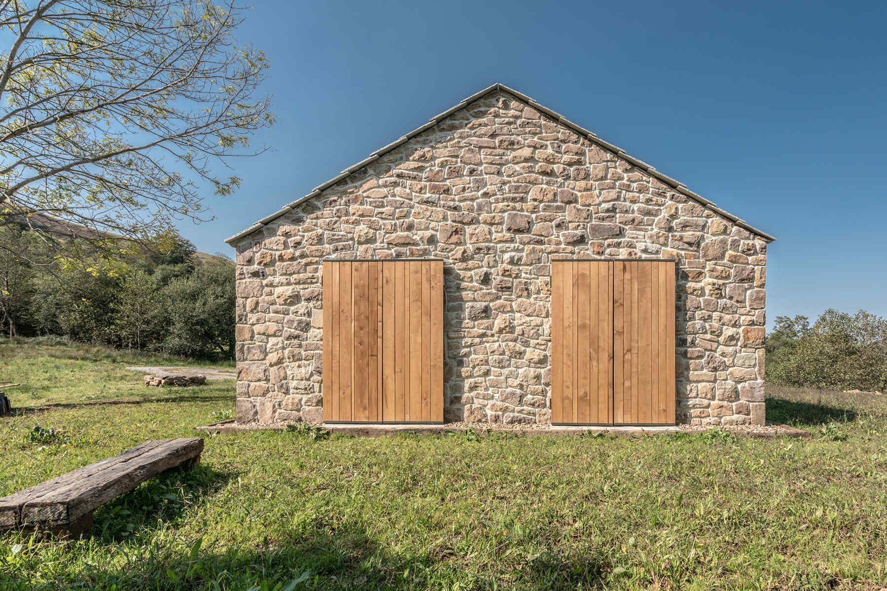Every bedroom of this stone cottage opens out to the grassy field beyond, catching the soft morning light that pours in from the east. Wood shutters can be closed when needed.