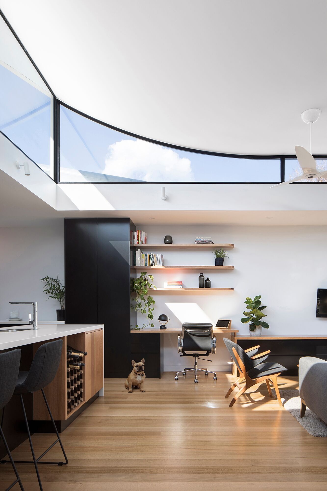 A curved roofline with clerestory windows fills the open plan living, dining and kitchen with sunlight, making the compact terrace feel expansive.