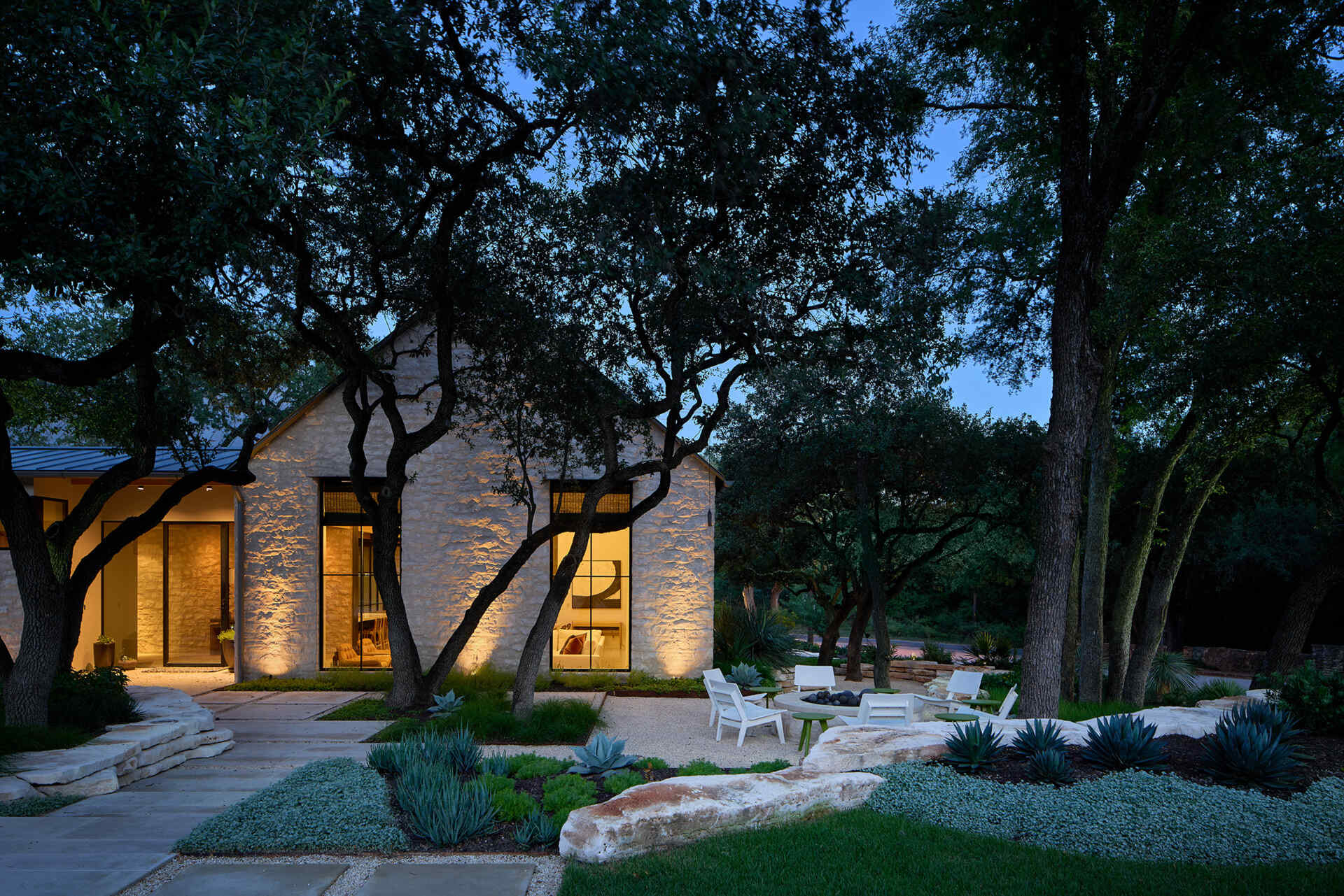 A modest street view hides a courtyard home filled with natural light, limestone, and wood by Furman & Keil Architects.