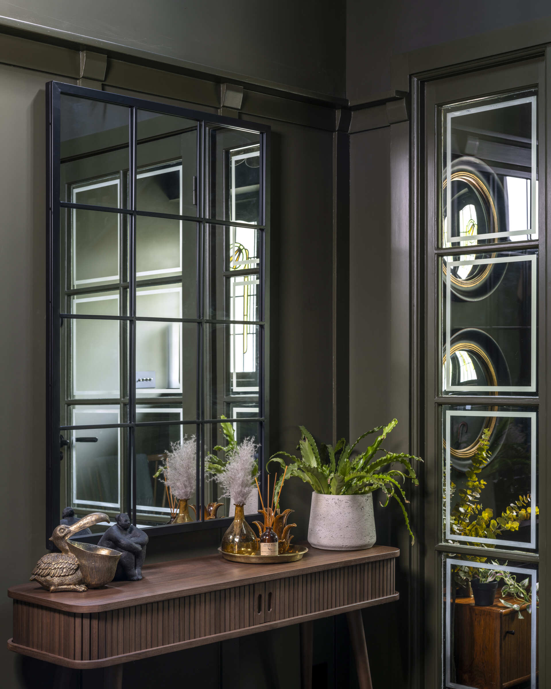 Stepping through the front door now reveals a sense of openness that didn’t exist before. The restored original staircase anchors the foyer, drawing the eye upward toward the light that filters through the new galleried stairwell.