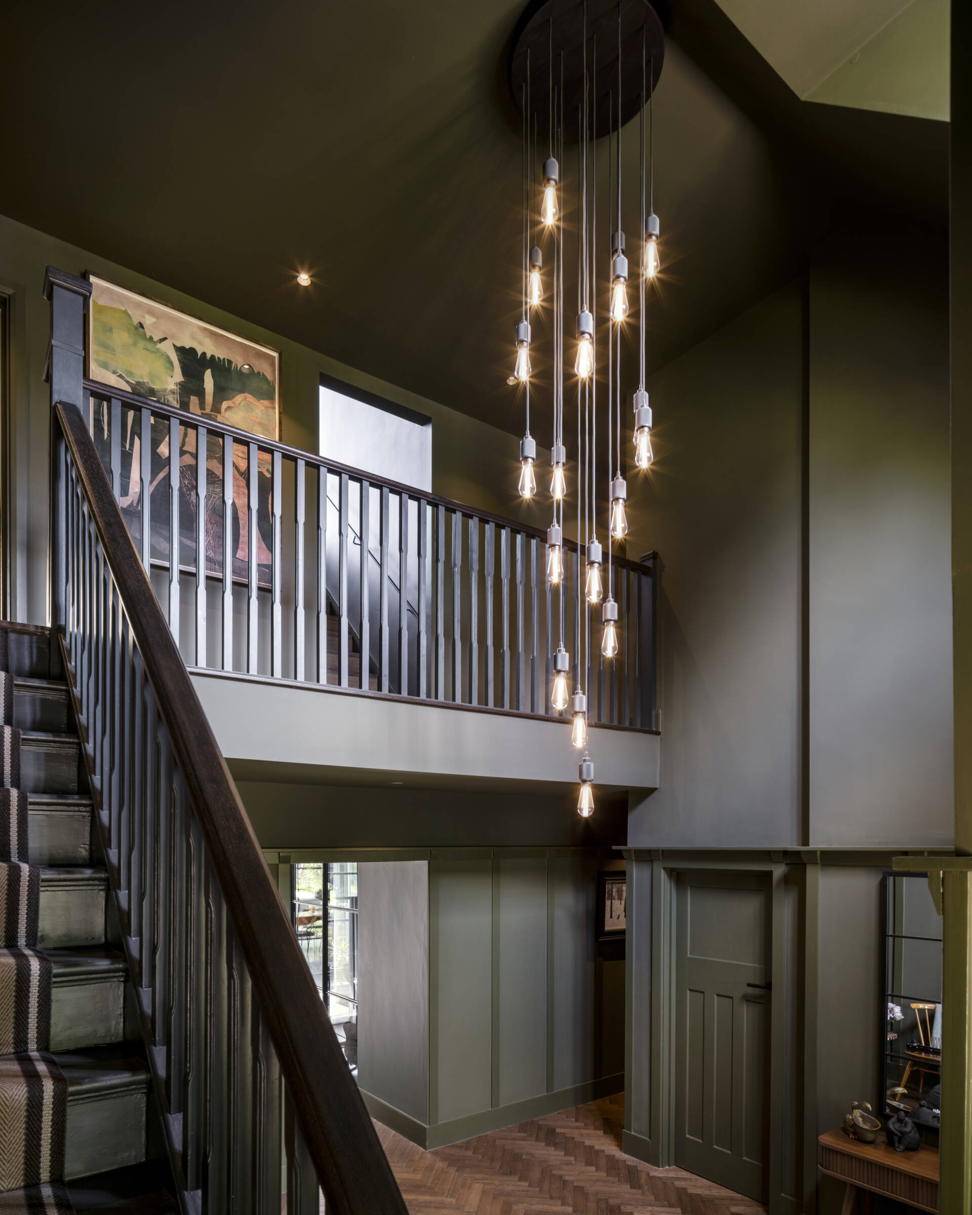 The foyer’s original staircase now glows with natural light, blending old craftsmanship with modern warmth.