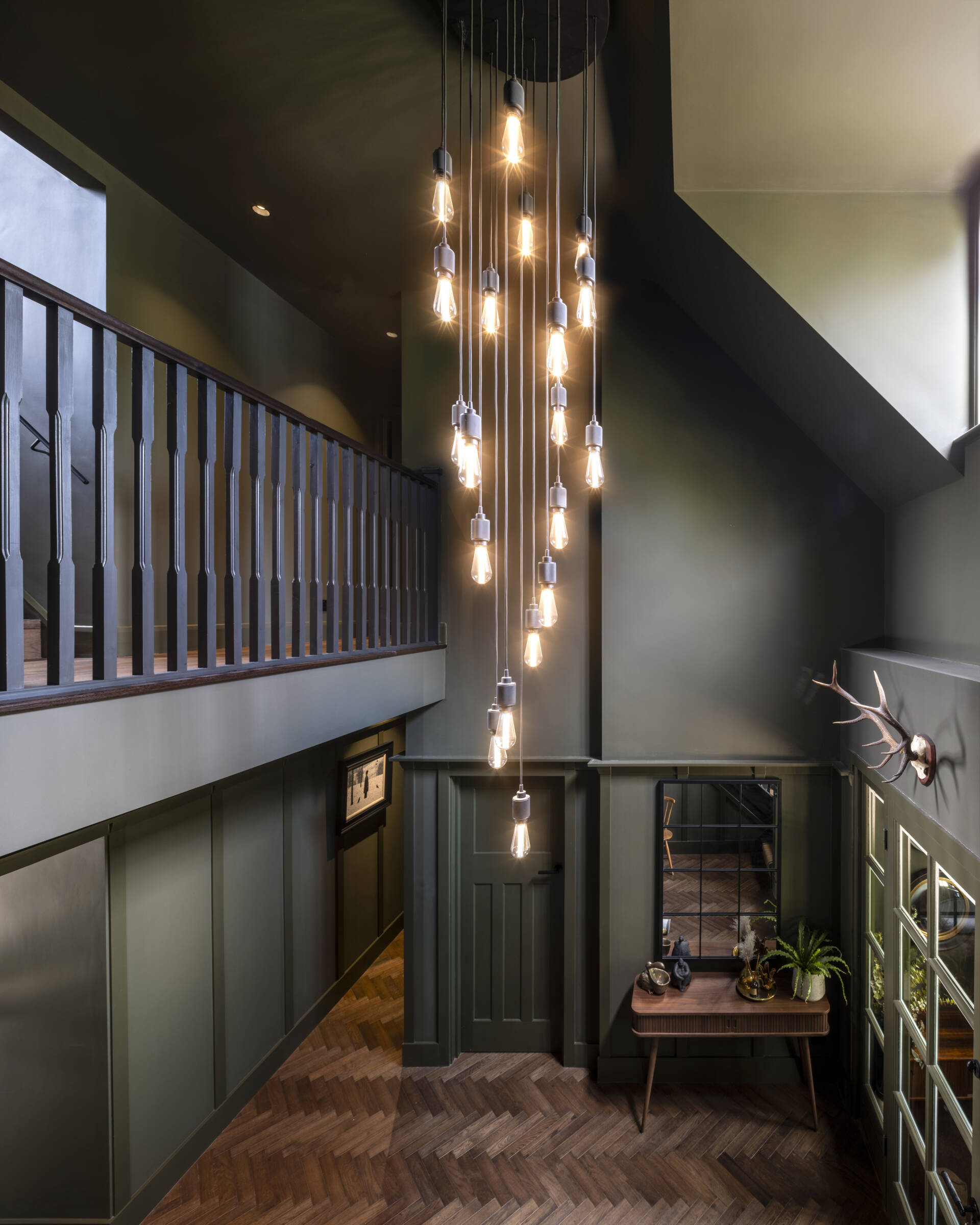 The foyer’s original staircase now glows with natural light, blending old craftsmanship with modern warmth.