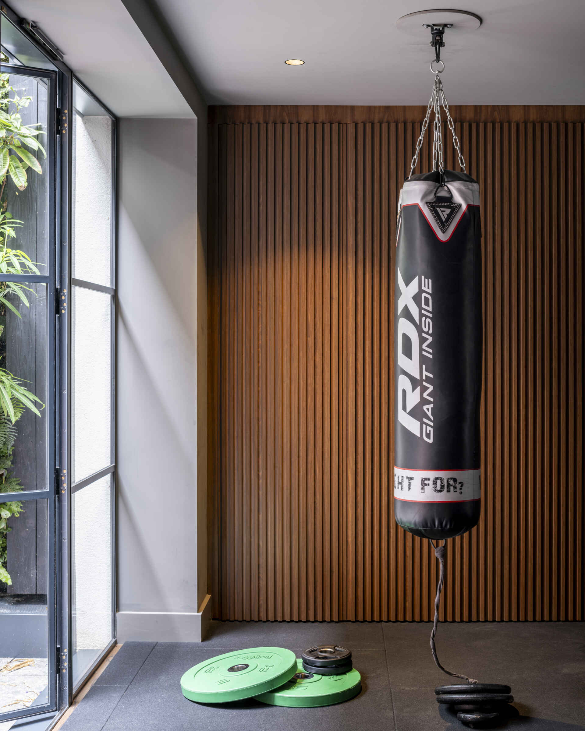 Adjacent to the courtyard, a compact gym offers a convenient place to recharge. It connects to the basement’s social spaces and opens directly to fresh air and greenery.
