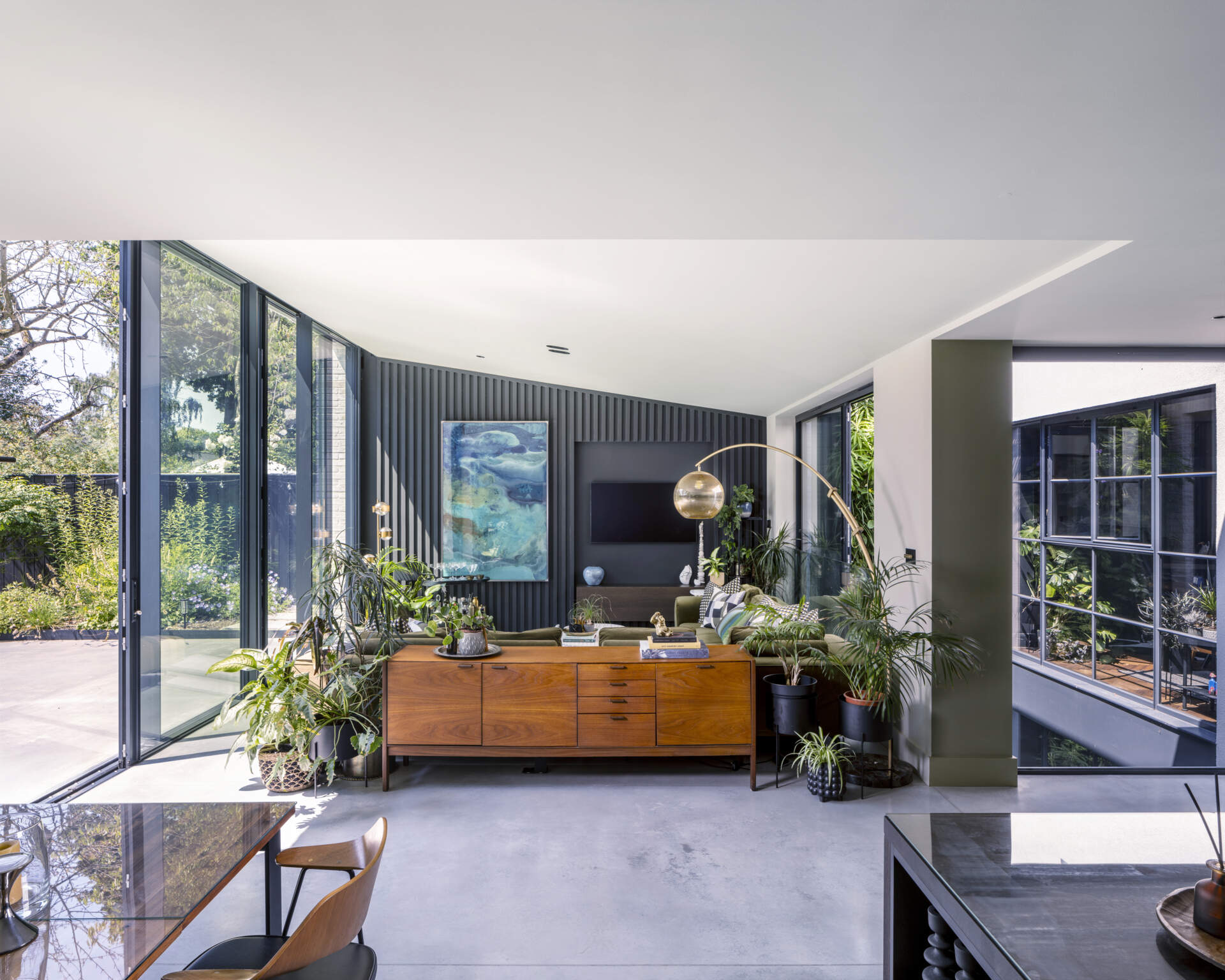 The bright, open-plan living room is where the family gathers, surrounded by warm materials and natural light.
