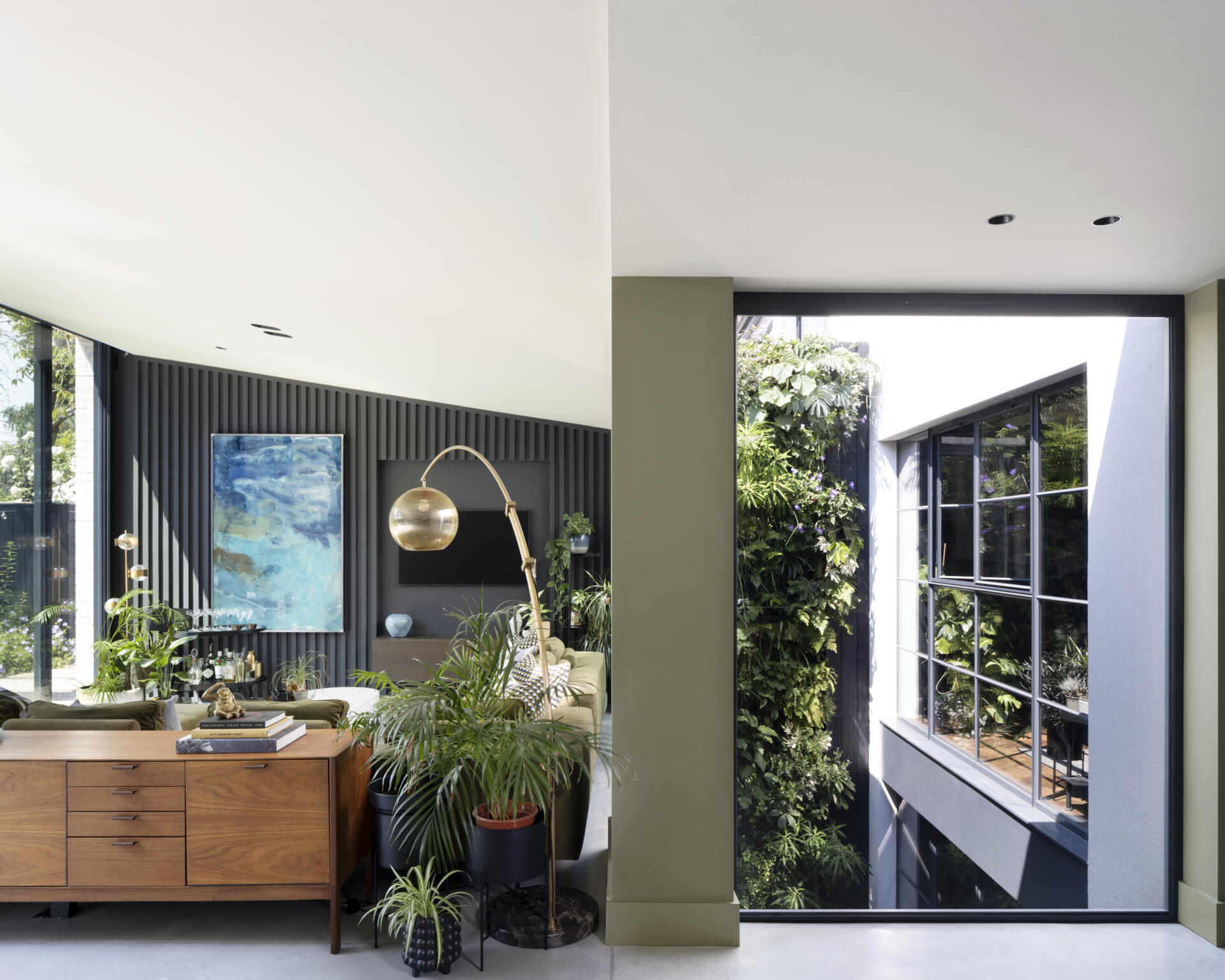 The bright, open-plan living room is where the family gathers, surrounded by warm materials and natural light.