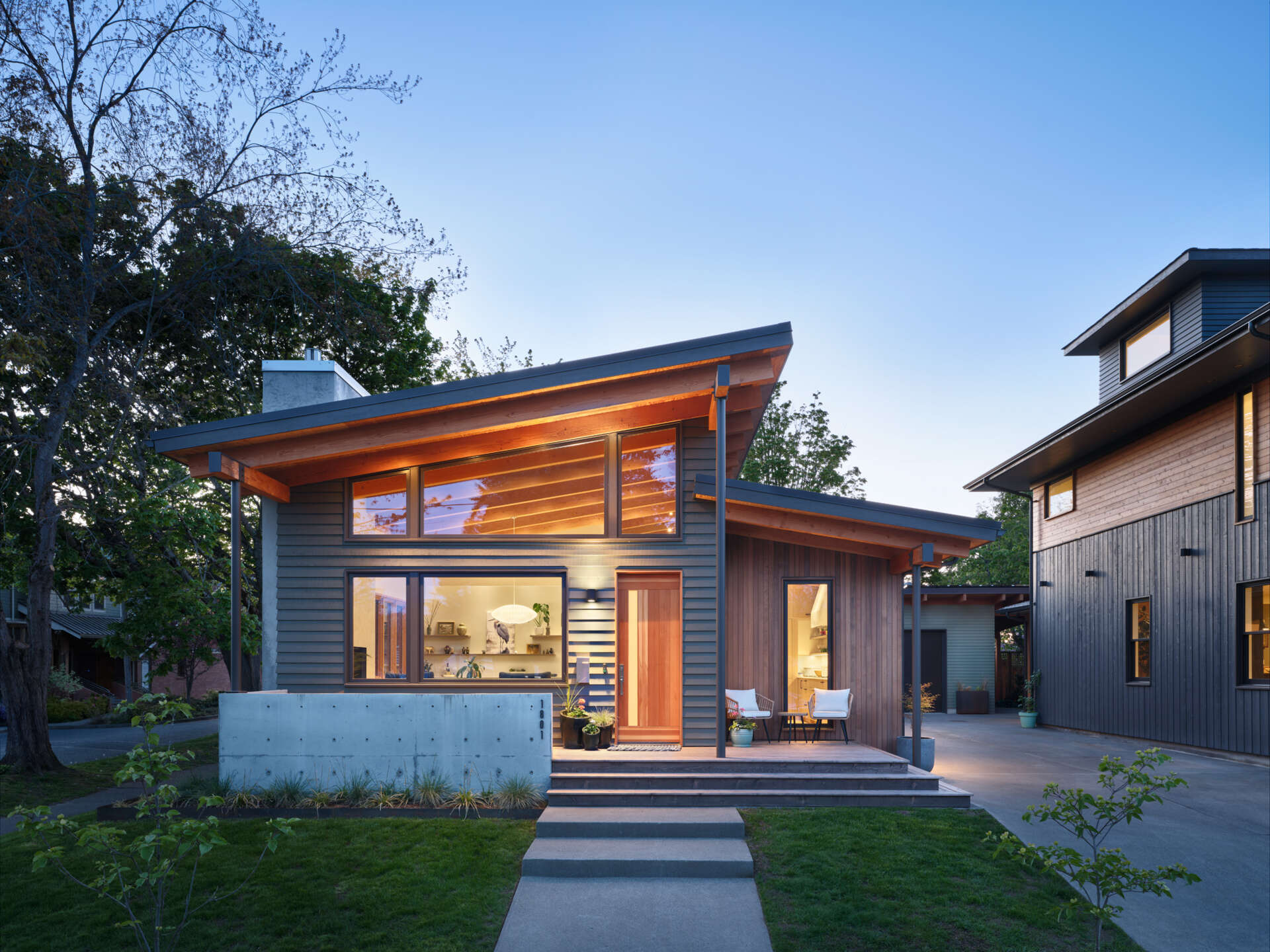 A modern ADU in the style of Pacific Northwest architecture, with a sloping roof and exposed wood beams.