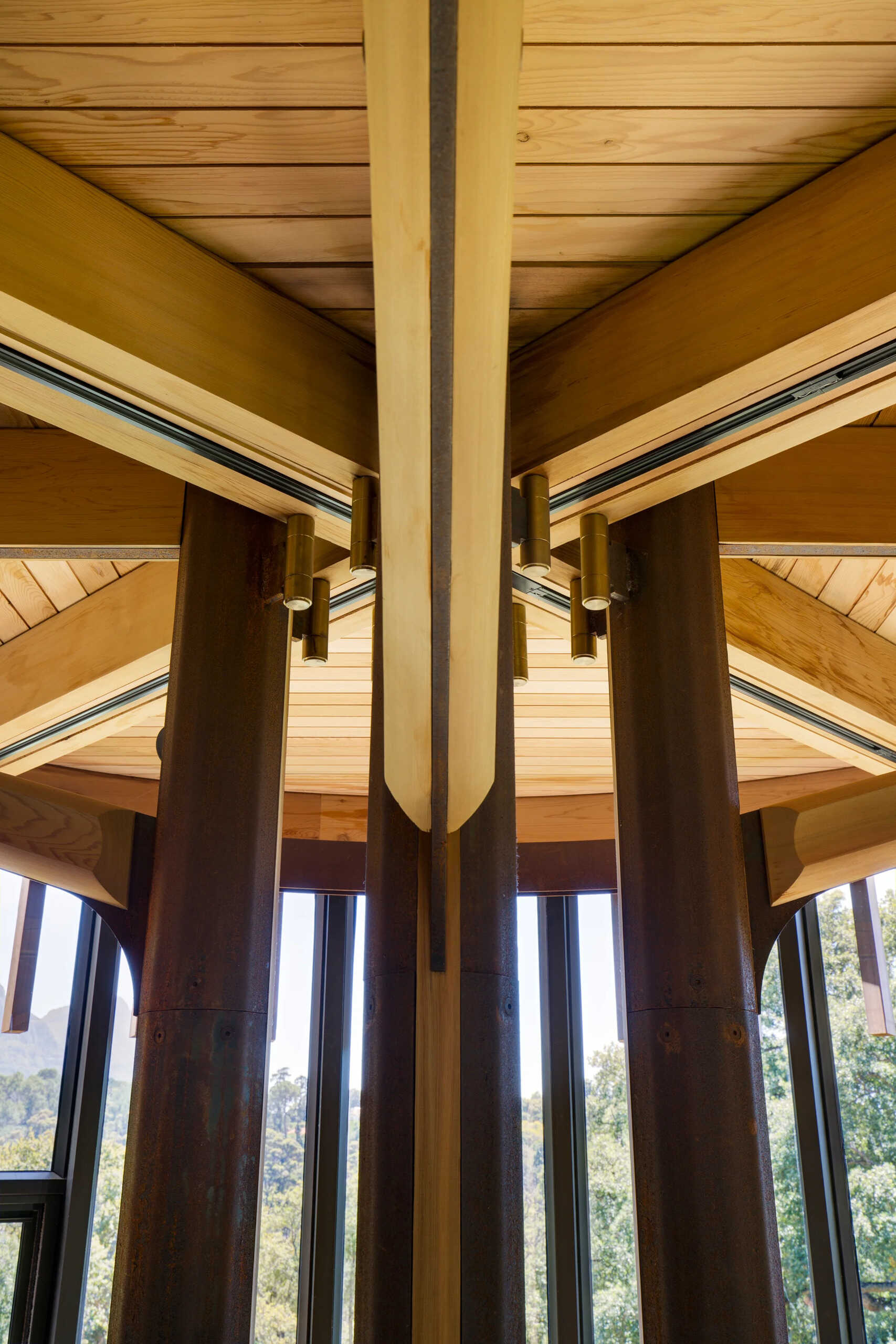 Branch-like steel arms and handcrafted brass details reveal the structure’s geometric precision.