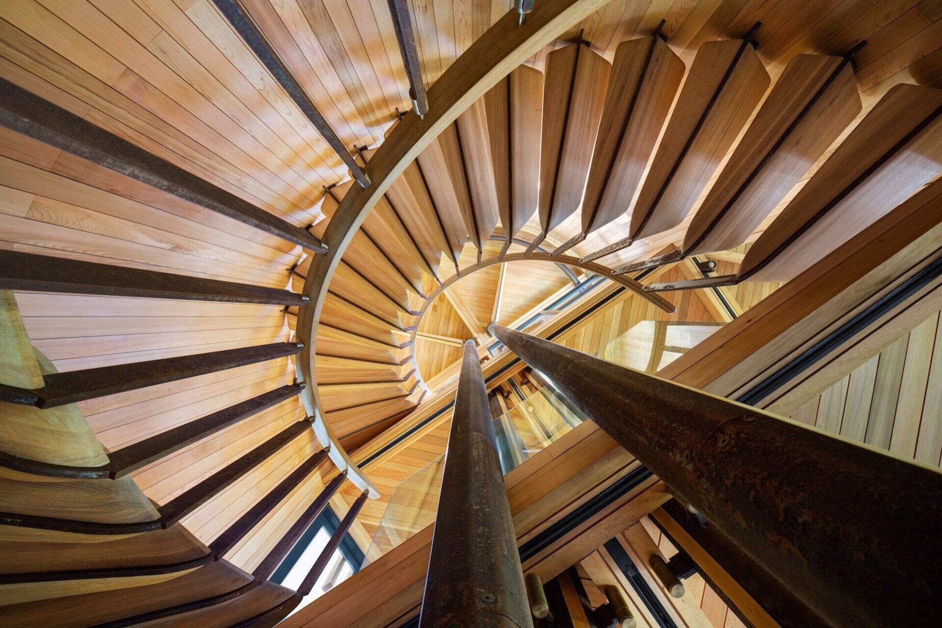 A spiral staircase of timber and steel winds through the home, connecting its canopy-level spaces.