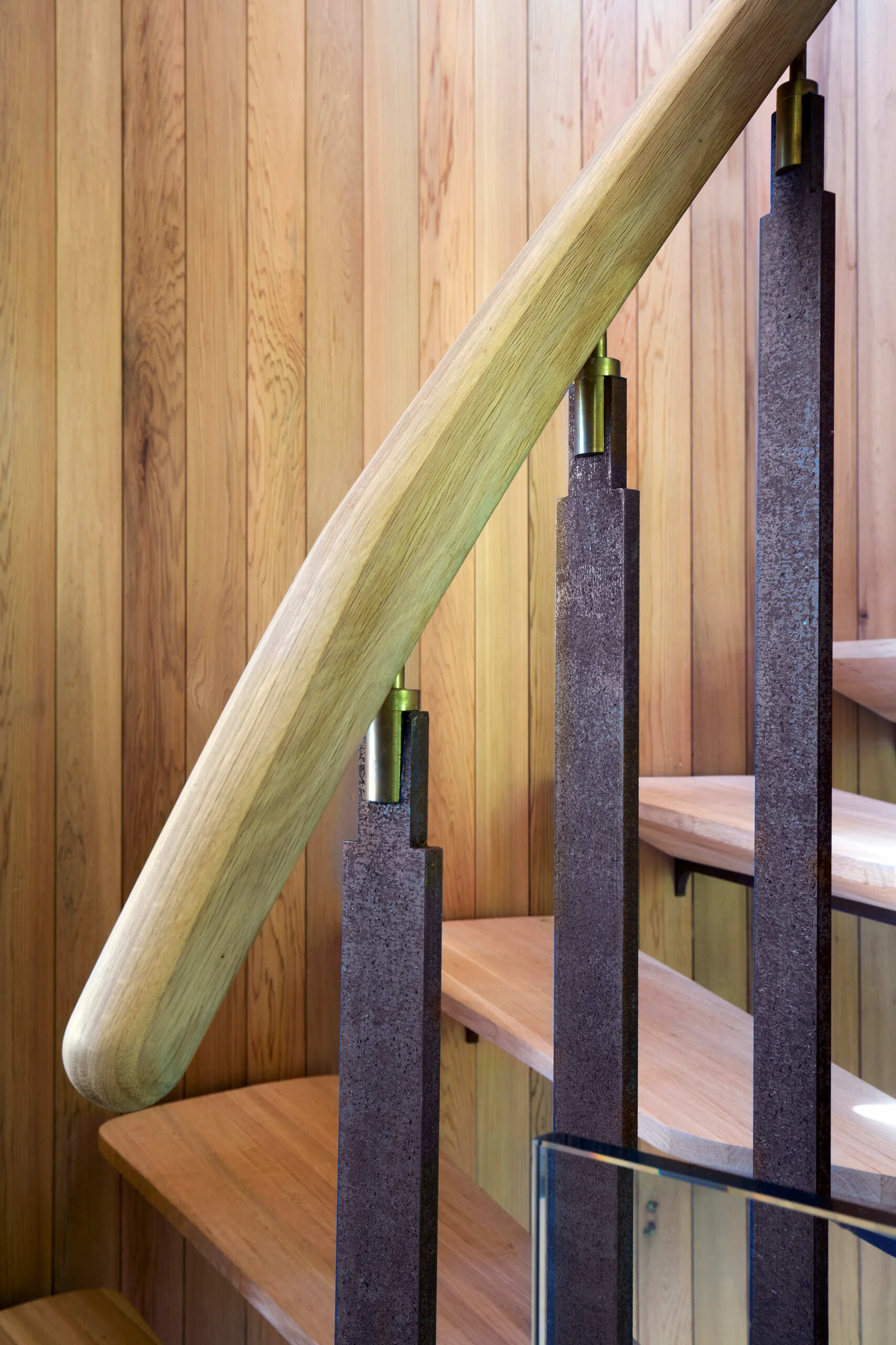A spiral staircase of timber and steel winds through the home, connecting its canopy-level spaces.