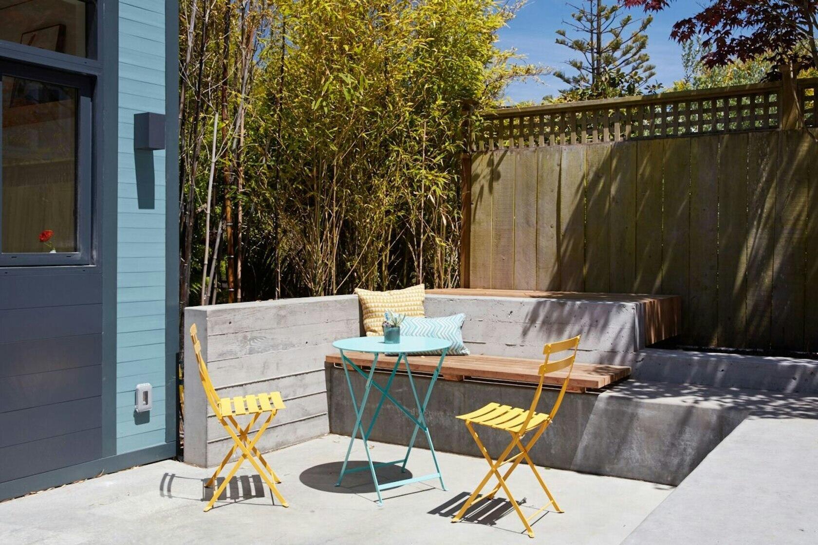 A beautifully redesigned San Francisco courtyard with bluestone pavers and board-formed concrete benches, creating a calm outdoor space between home and studio.