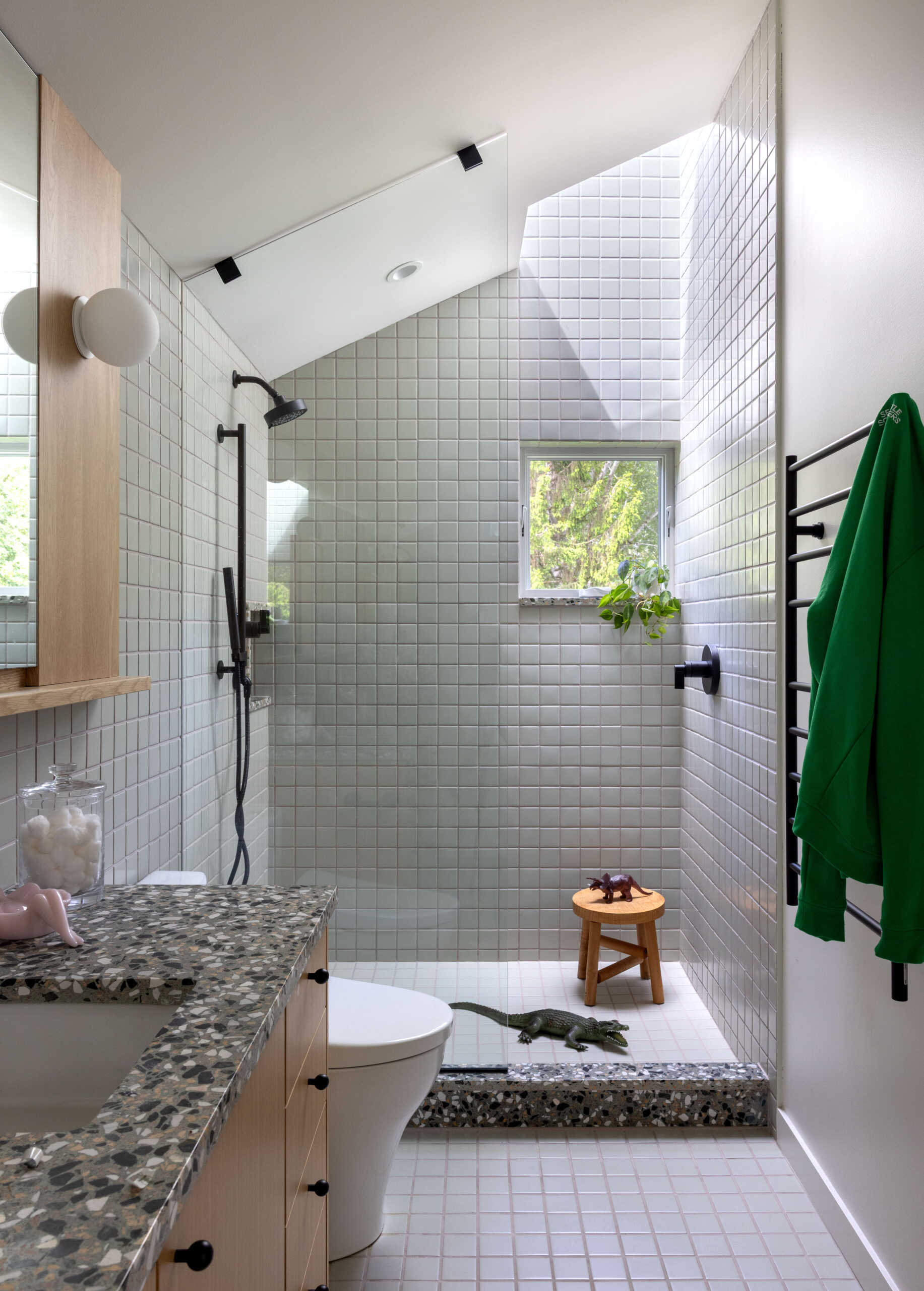 A modern bathroom with square grey tiles lining the shower.