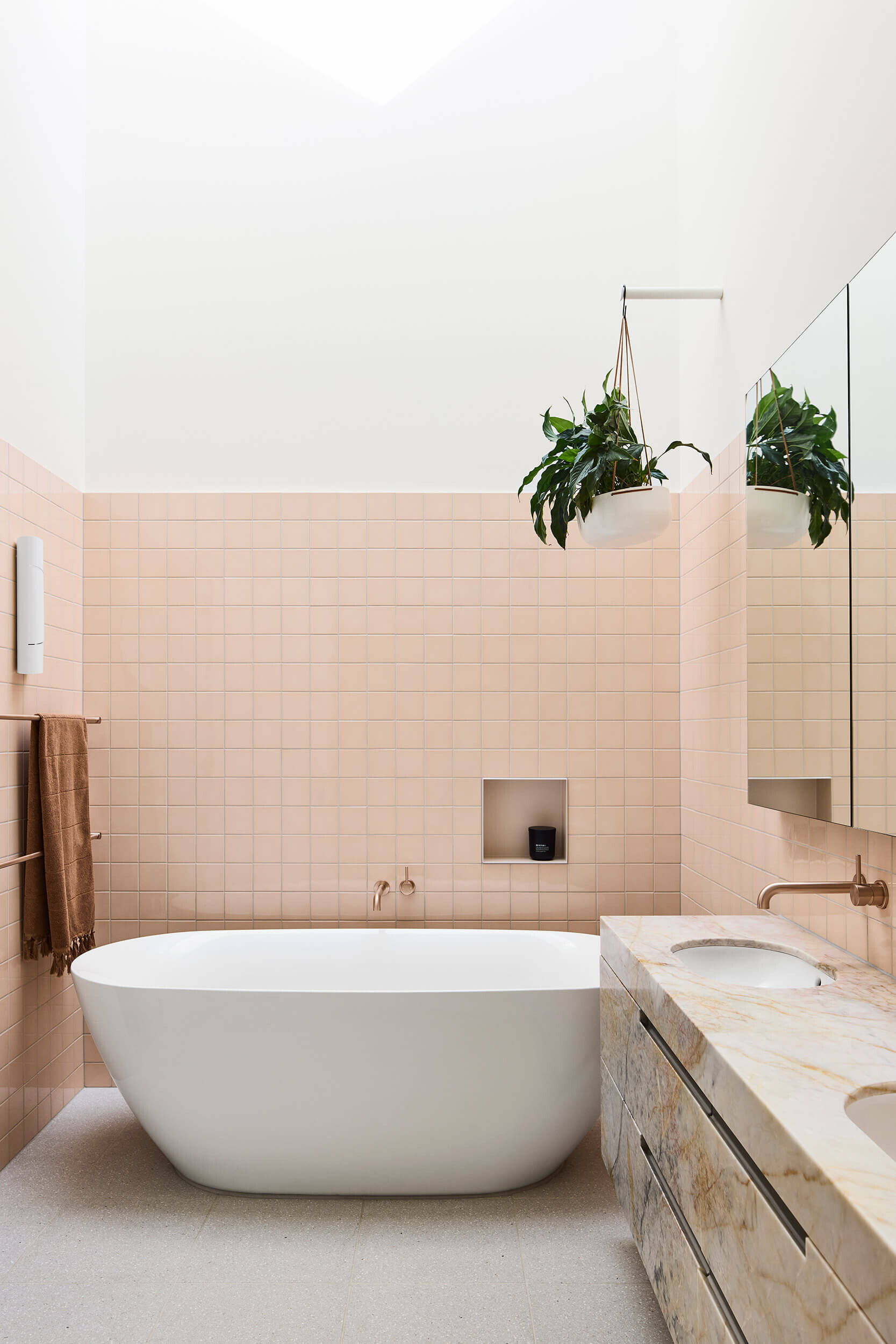 Australian marble with apricot and copper undertones carries through this ensuite bathroom, where color and texture build a sense of intimacy.