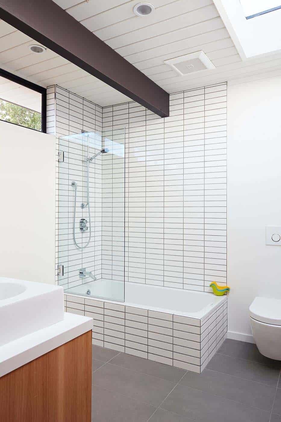 Elegant bathrooms with soft grey tones and bright finishes complete this Eichler’s understated modern look.