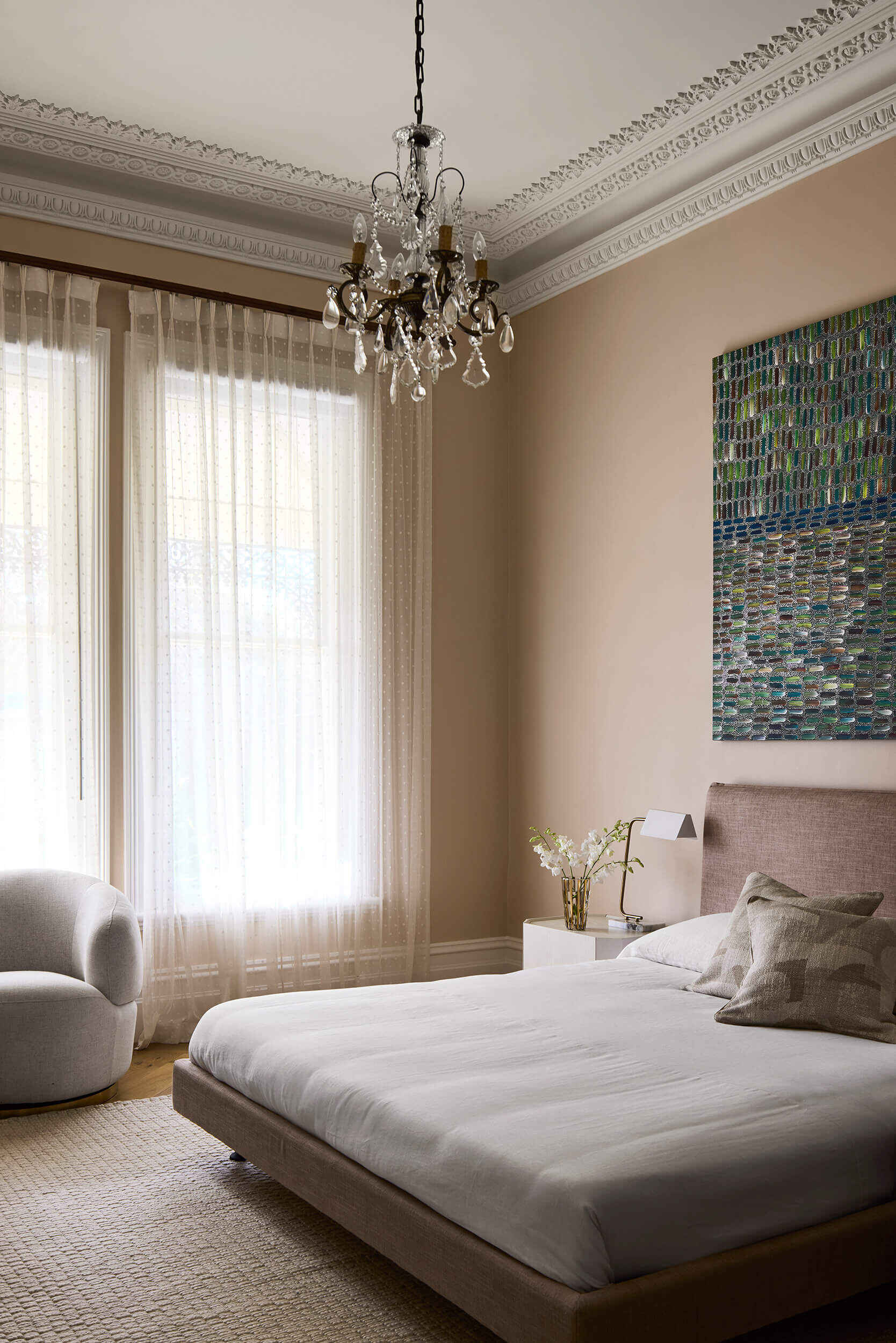 Inspired by the home’s original leadlight windows, the primary suite embraces a soft pink palette. Australian marble with apricot and copper undertones carries through the ensuite, where color and texture build a sense of intimacy.