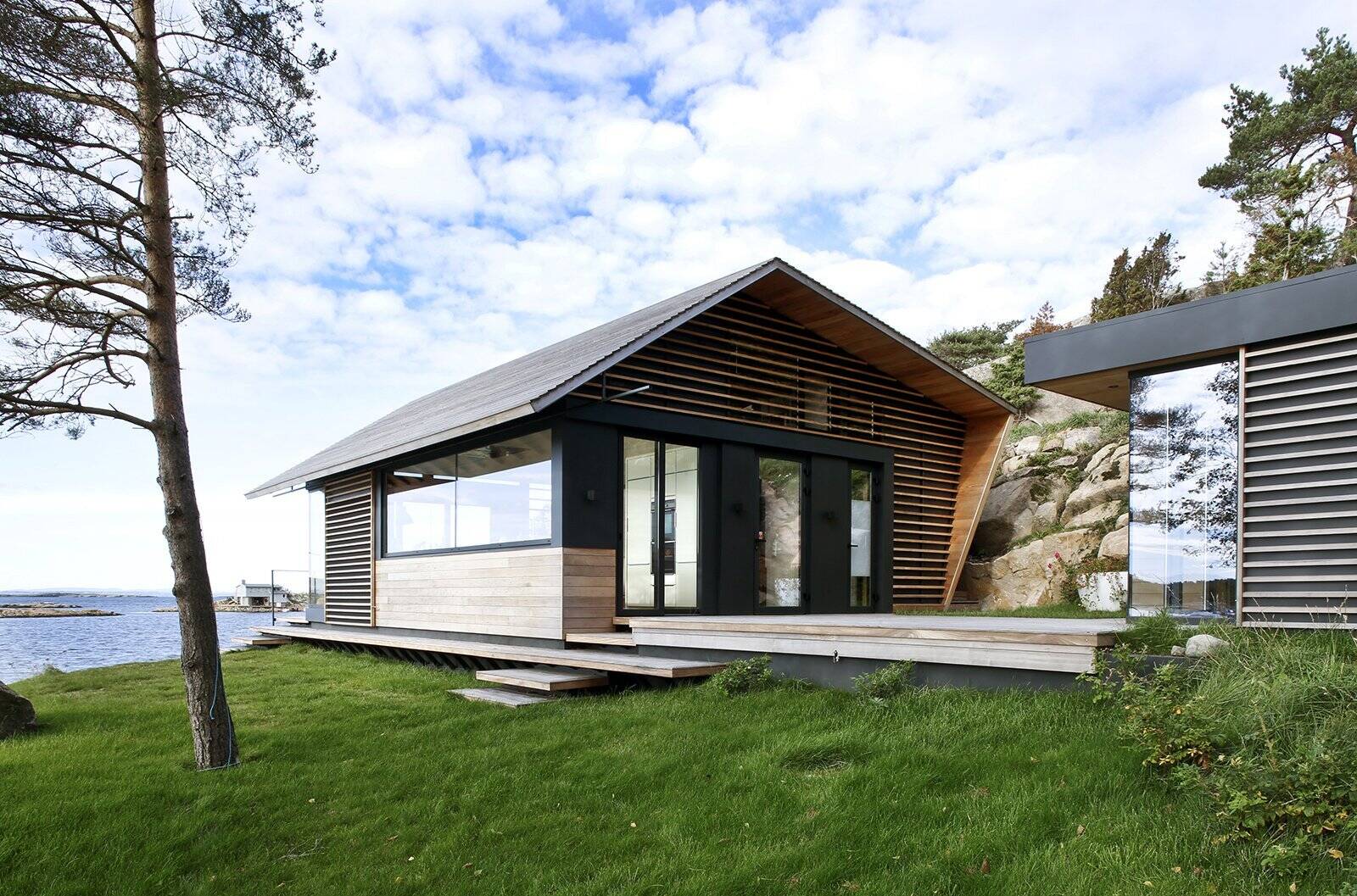 A modern cedar-clad cabin by the water seamlessly blends architecture and landscape.