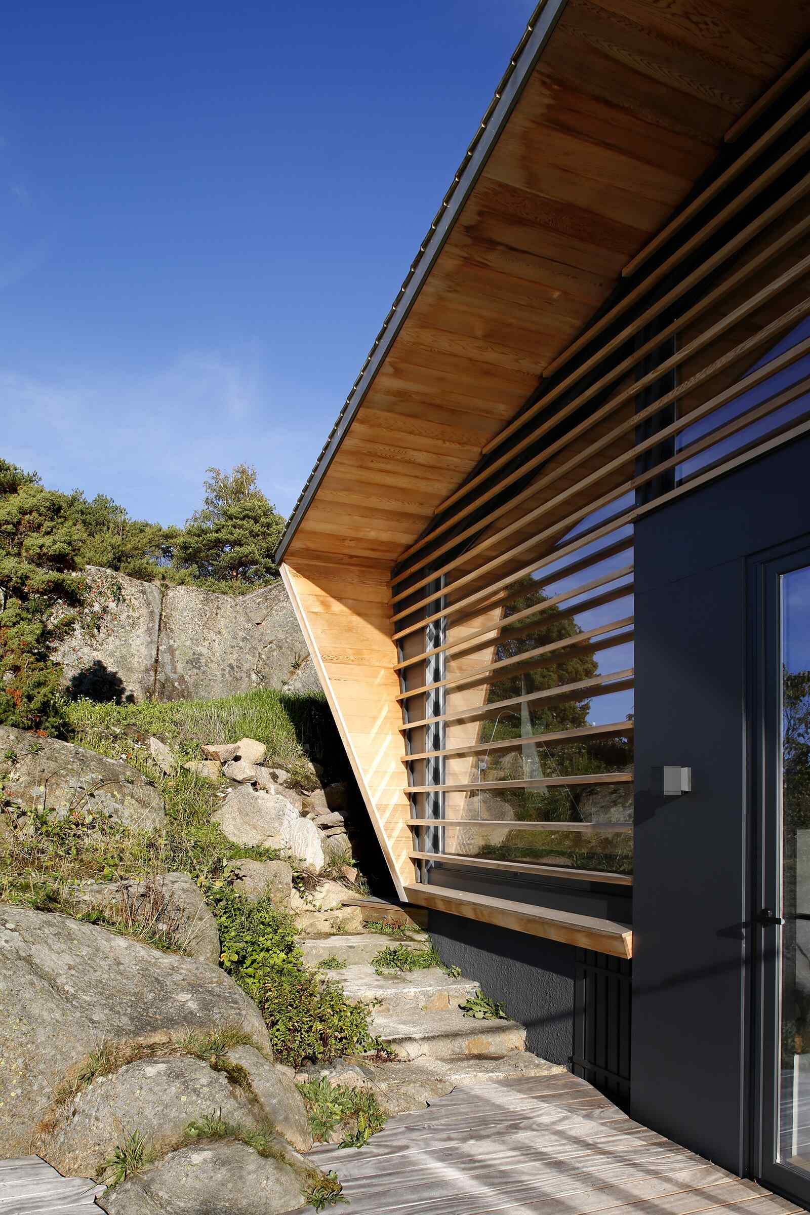 A modern cedar-clad cabin by the water seamlessly blends architecture and landscape.