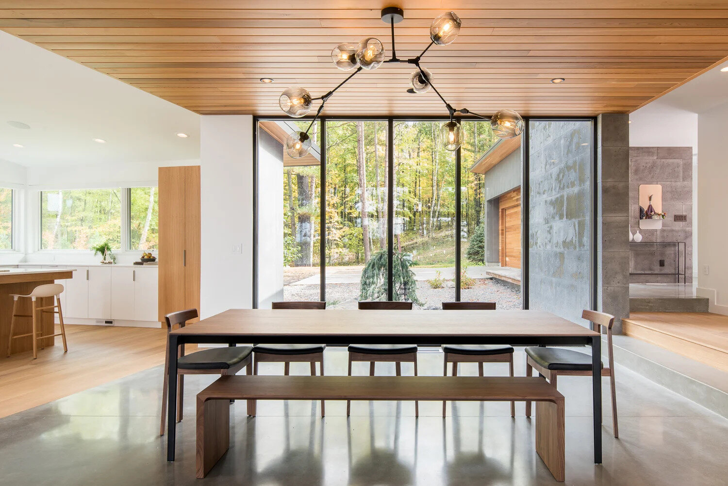 A glass core creates an abundance of light and shows off the lake views and becomes the dining room. The glass walls also separate the large dining area from a enclosed porch. When needed the glass wall can be opened to expose the porch and increase the size of the interior space.