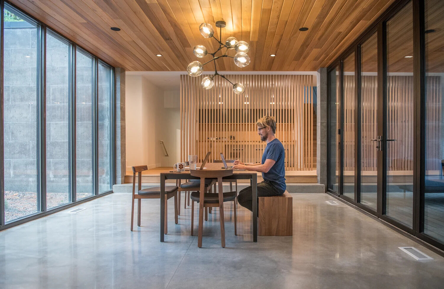 A glass core creates an abundance of light and shows off the lake views and becomes the dining room. The glass walls also separate the large dining area from a enclosed porch. When needed the glass wall can be opened to expose the porch and increase the size of the interior space.