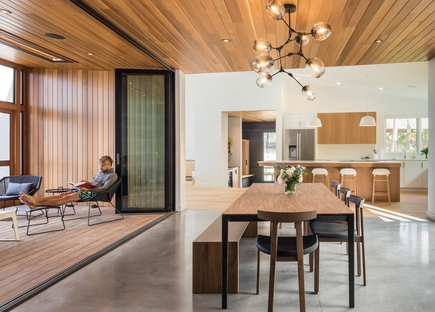 A glass core creates an abundance of light and shows off the lake views and becomes the dining room. The glass walls also separate the large dining area from a enclosed porch. When needed the glass wall can be opened to expose the porch and increase the size of the interior space.