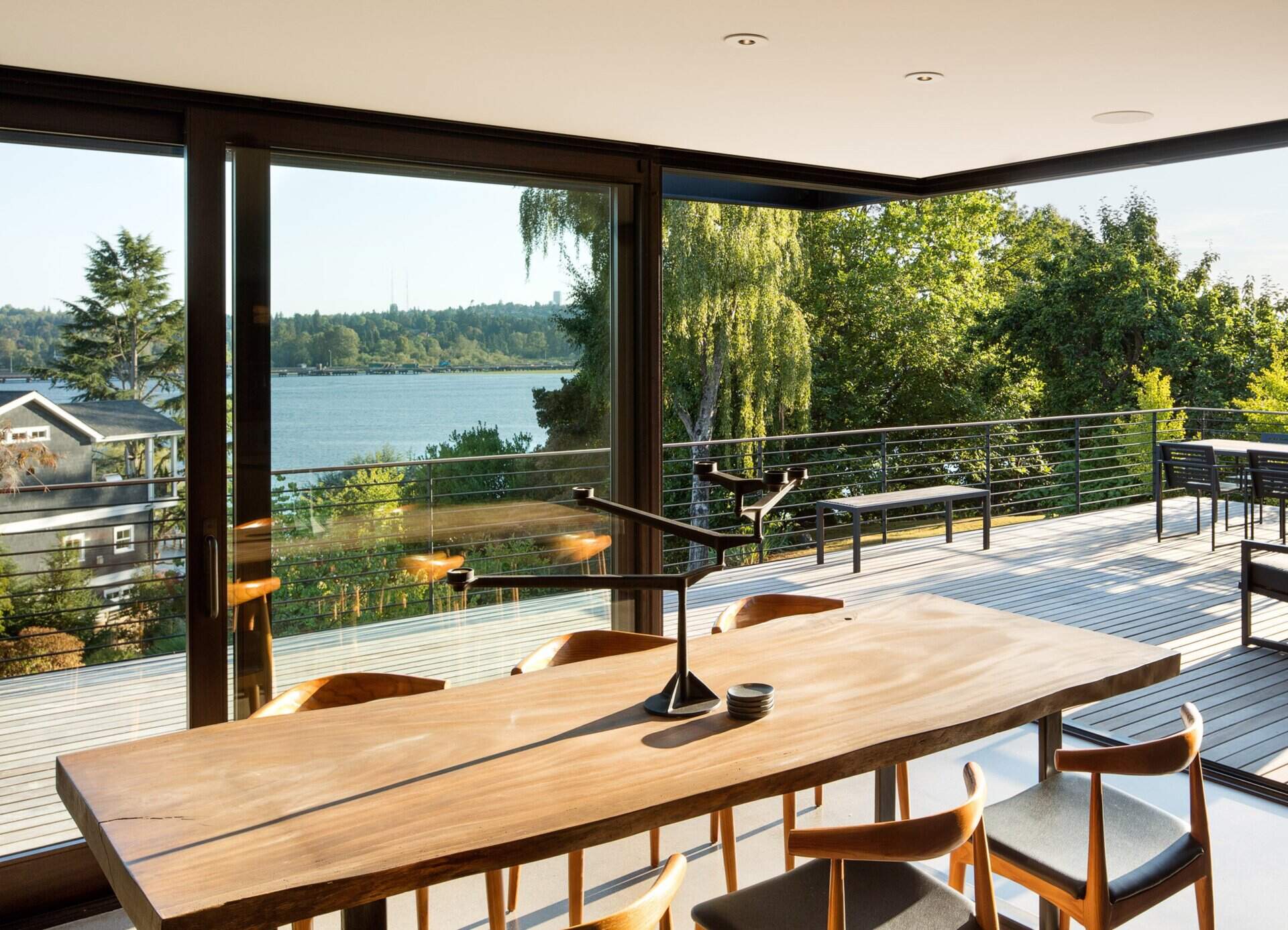 Dark wood and gray cabinetry bring warmth and sophistication to a kitchen now opened up to the dining area and lake-view deck.