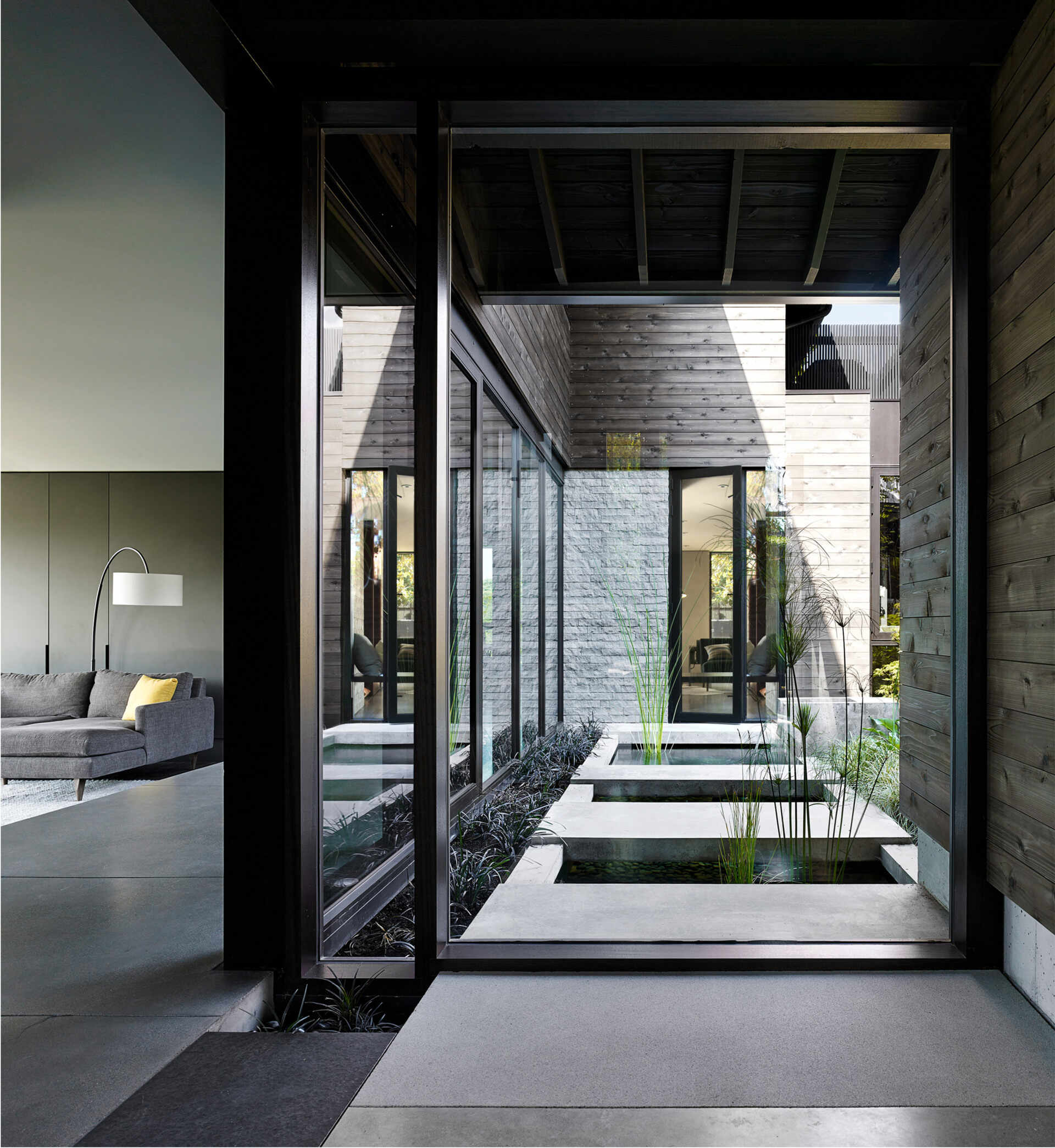 A lush courtyard with a concrete water feature connects every room to nature, serving as the peaceful heart of this renovated Laurelhurst home.