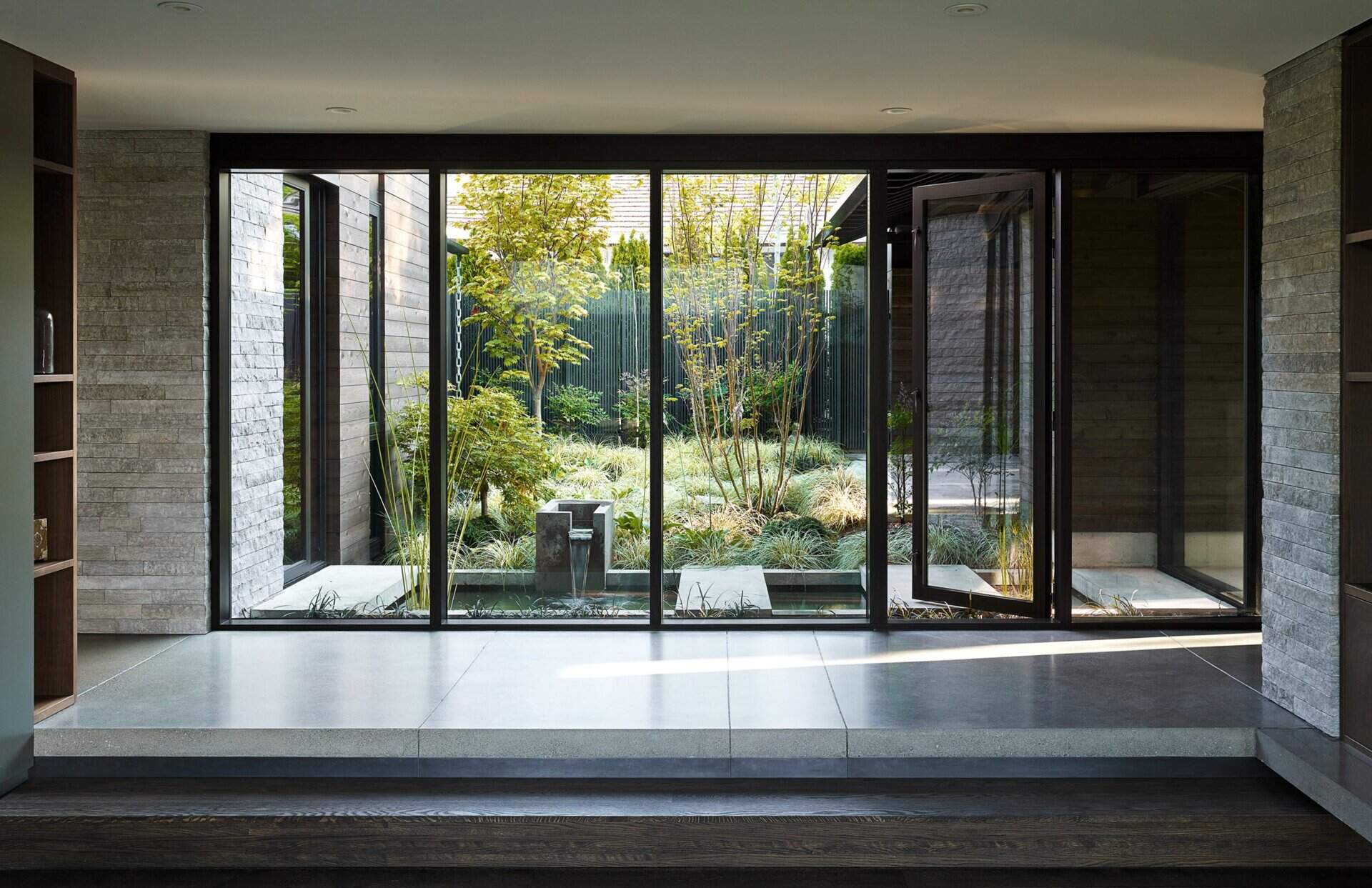A lush courtyard with a concrete water feature connects every room to nature, serving as the peaceful heart of this renovated Laurelhurst home.