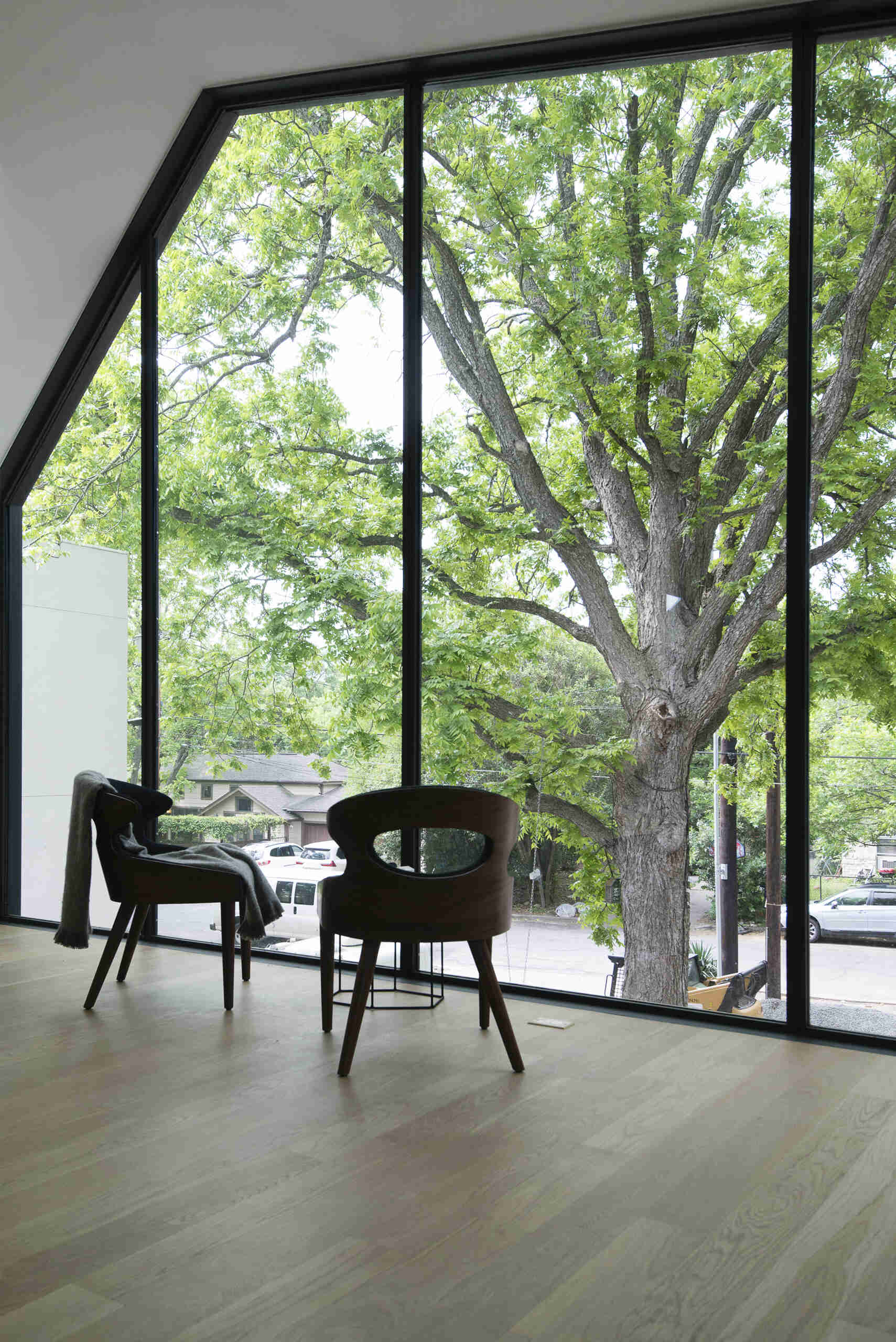 At the end of the hall lies the bedroom, dramatically cantilevered over the front of the home. From its floor-to-ceiling windows, the couple can look out to the trees and street below,  a serene retreat perched above their mechanical world.