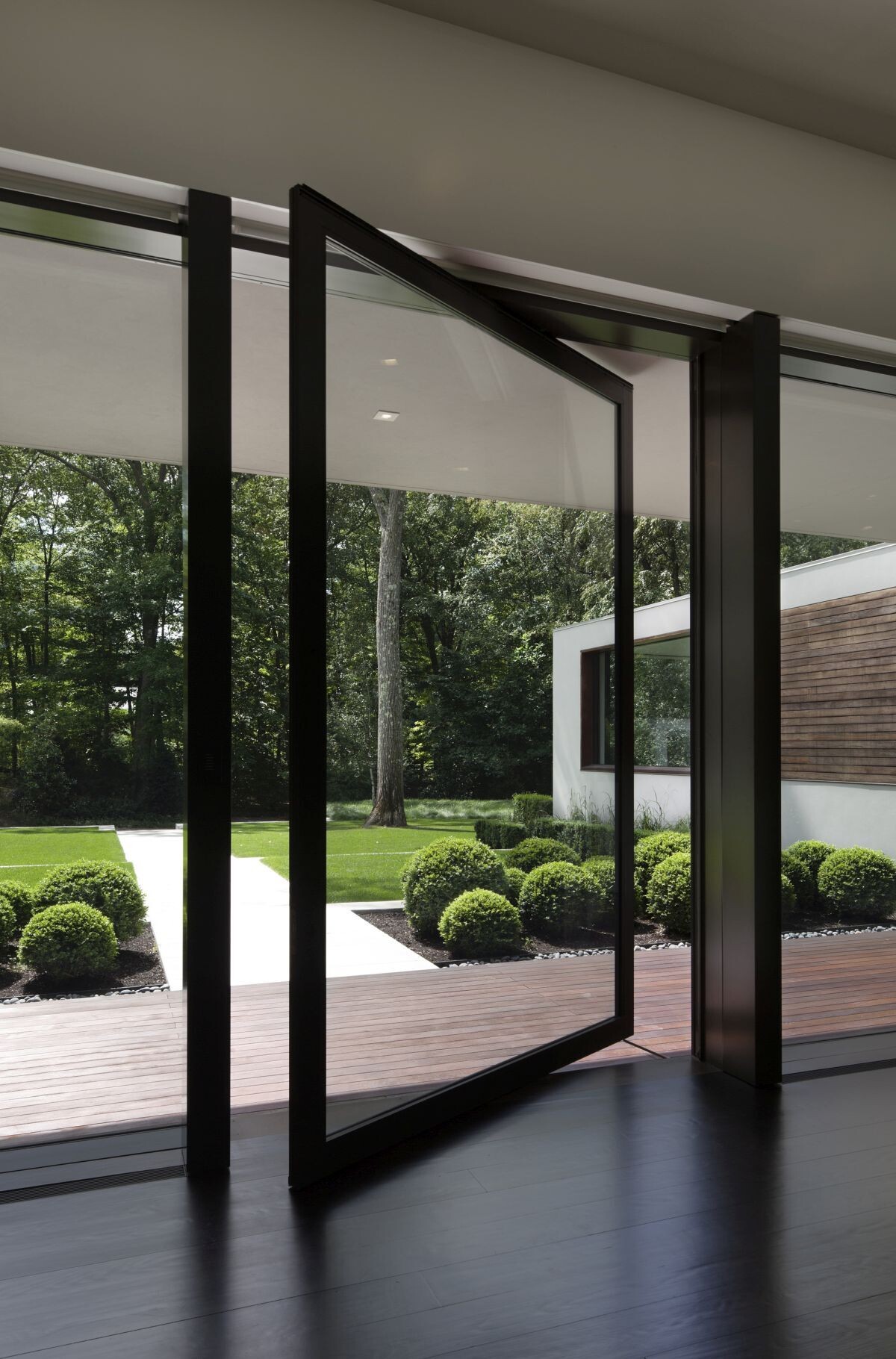 Oversized glass pivot doors combine dramatic design with smooth operation.