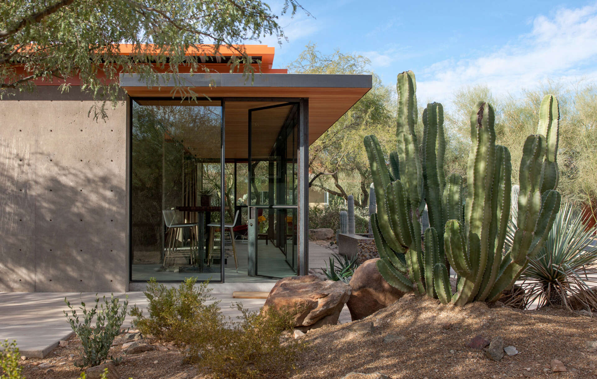 Once a working barn in Phoenix, this guest house by The Construction Zone features full-height glass, concrete, and Douglas fir details that highlight desert modernism.