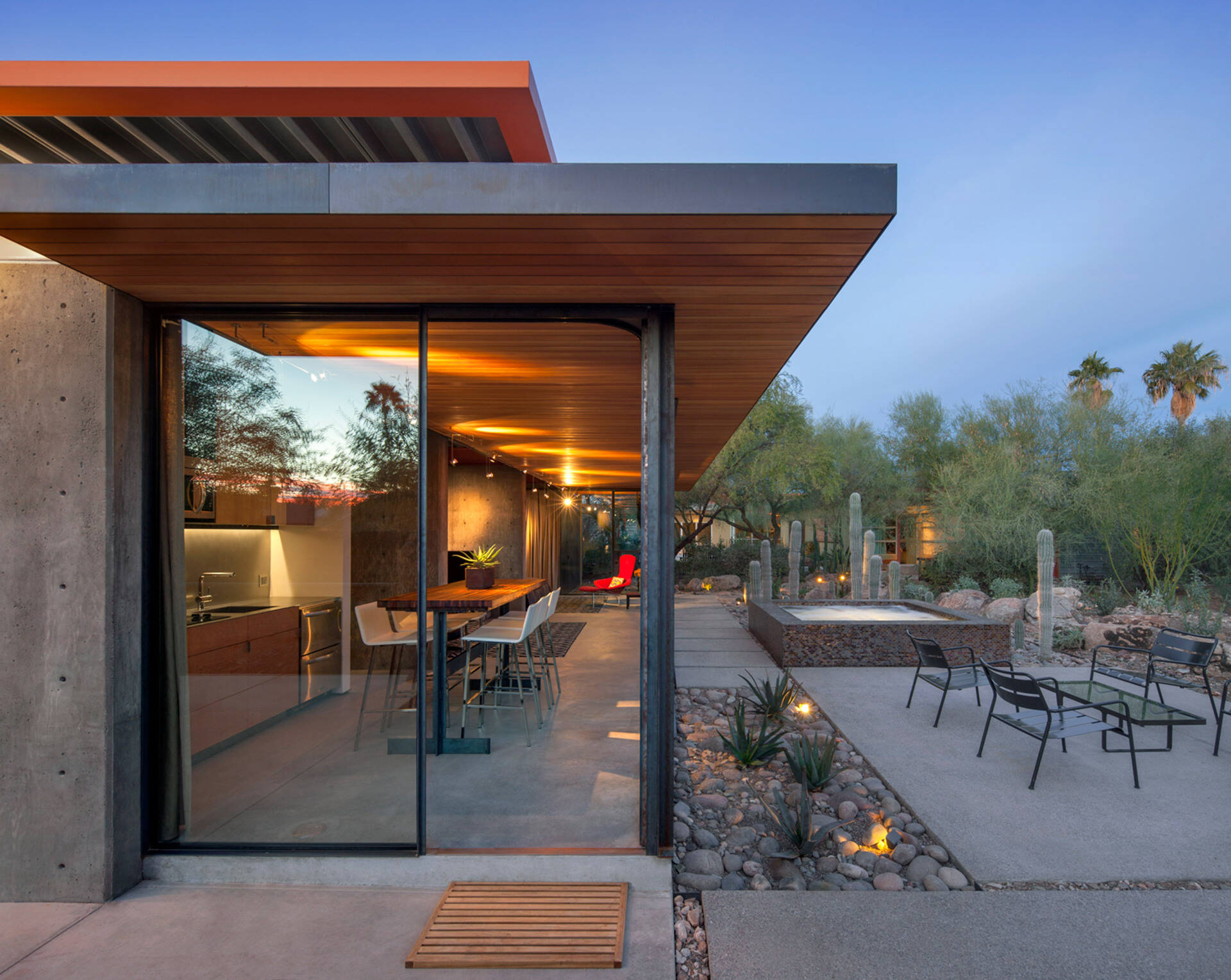 Once a working barn in Phoenix, this guest house by The Construction Zone features full-height glass, concrete, and Douglas fir details that highlight desert modernism.