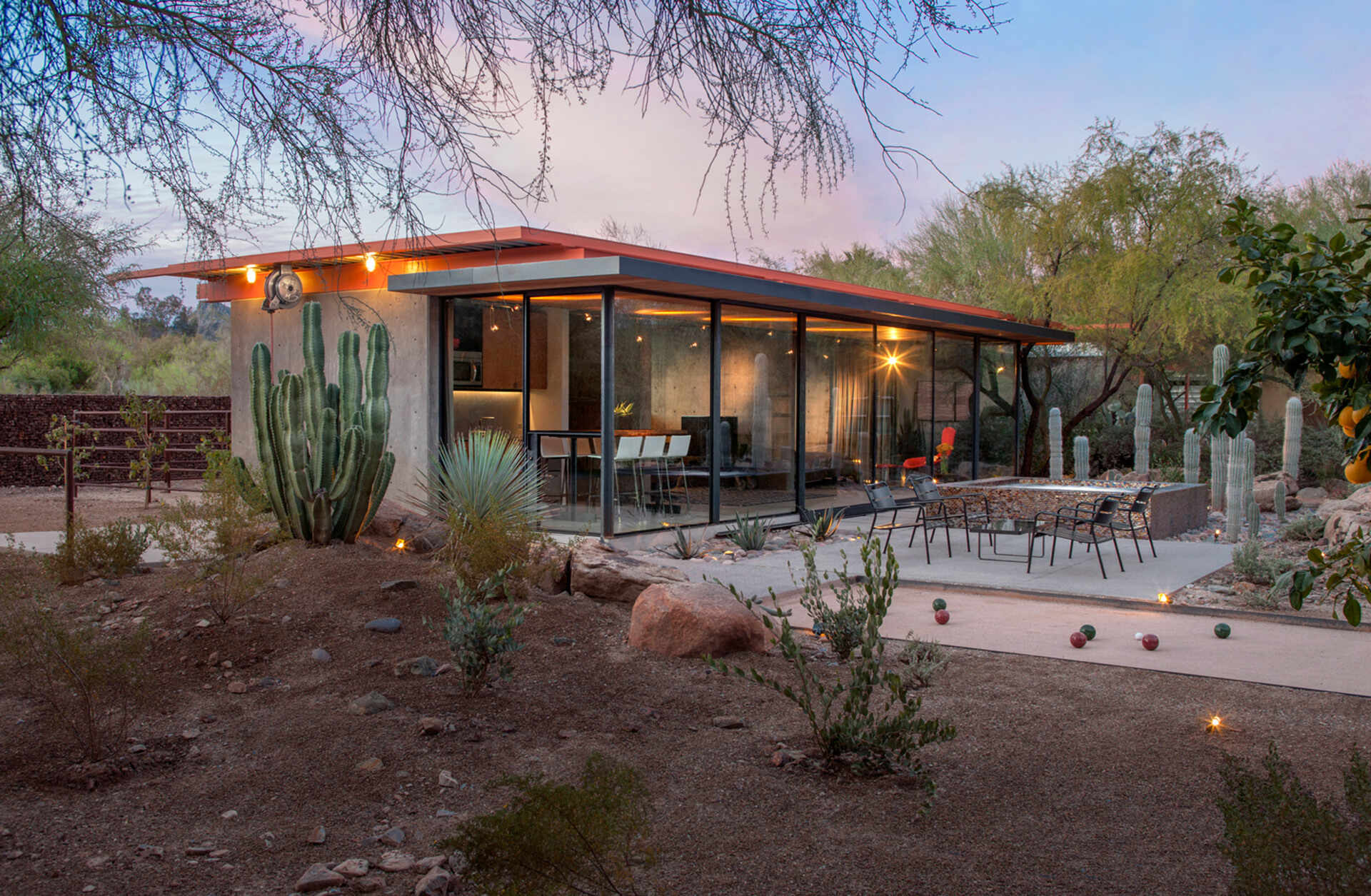 The surrounding patio includes a bocce ball court, jacuzzi, and desert landscaping that turns the former barnyard into an elegant outdoor retreat.