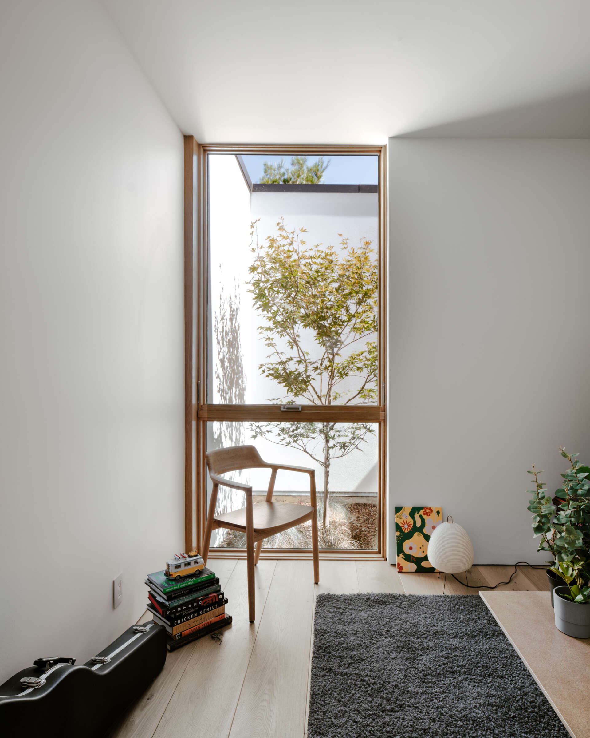A modestly scaled guest room at the end of the hallway maintains the home’s private, inward-focused layout. Natural materials and subtle details ensure comfort while keeping the space connected to the overall design language.