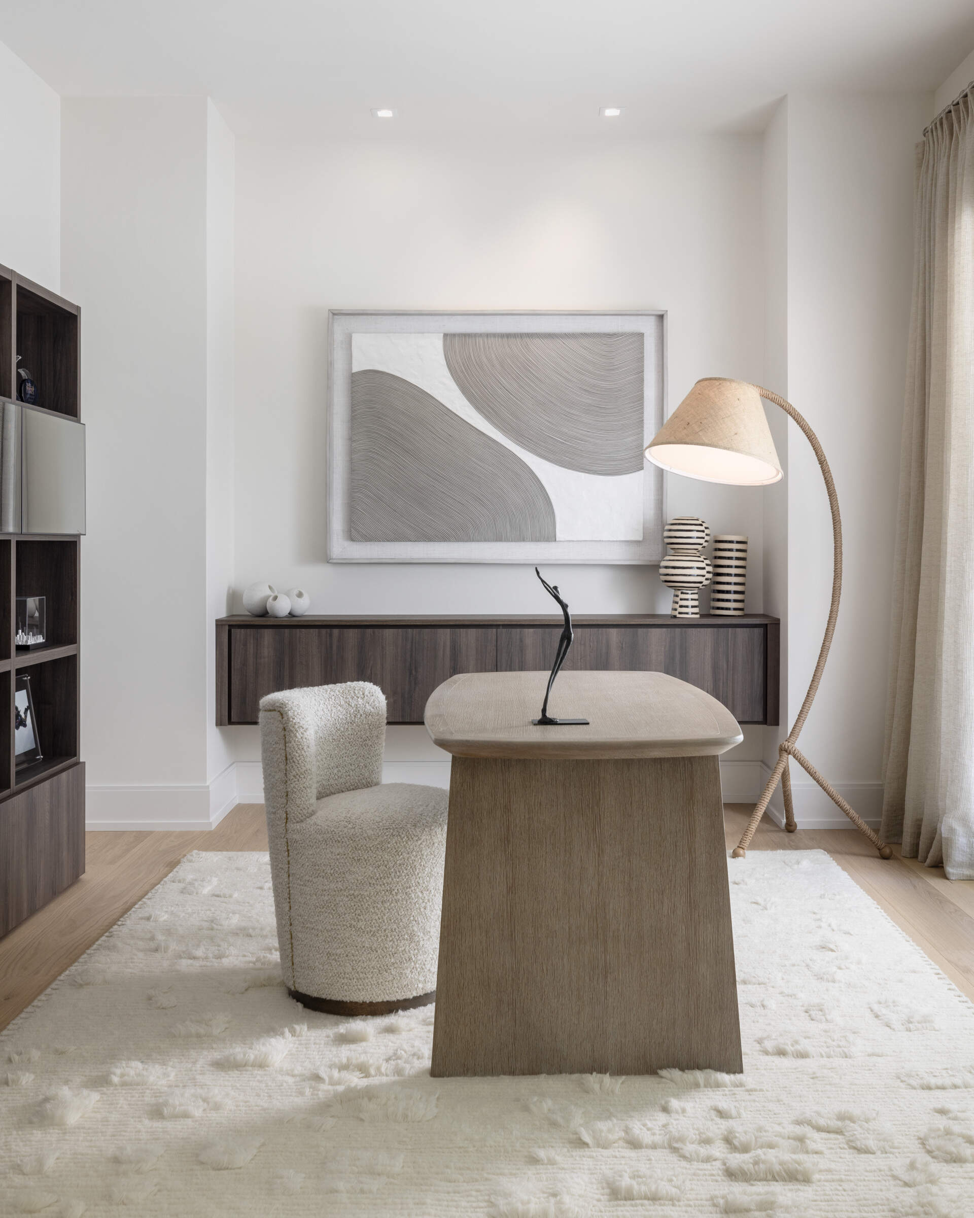 The home office proves neutral can be thrilling when the details are right. Clean shelves, a composed desk line, and layered light keep focus sharp. Zoom backdrop approved.