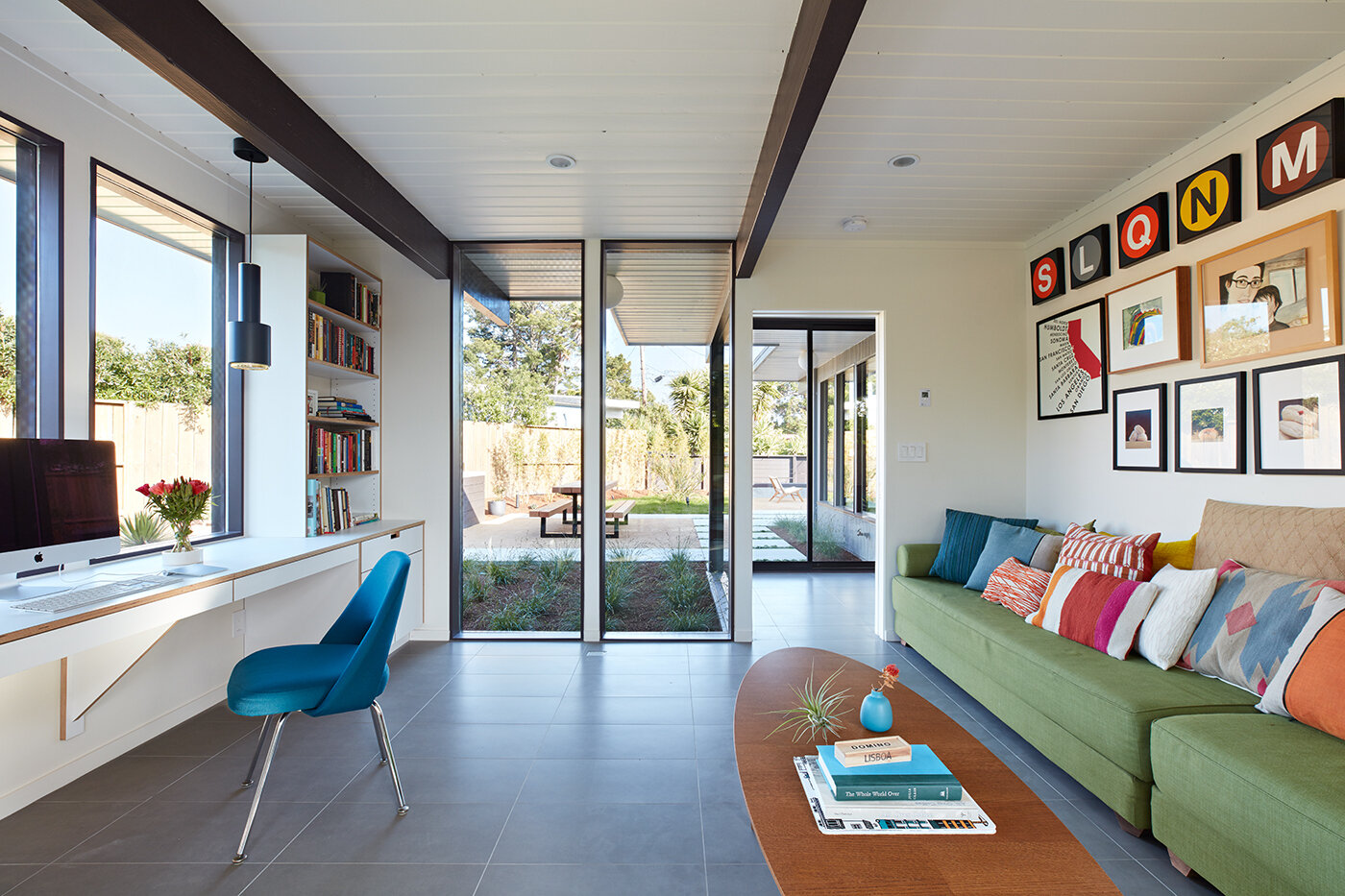A glass-wrapped Eichler addition designed for work and guests feels open, bright, and beautifully integrated with the yard.