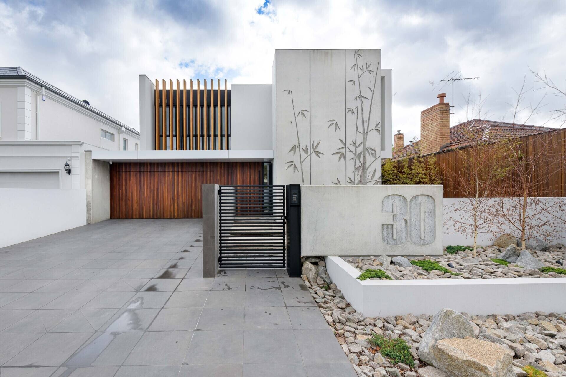 Tilt-up concrete panels with bamboo reliefs give this home a sculptural edge. The combination of raw concrete and natural texture strikes a balance between industrial and organic design.